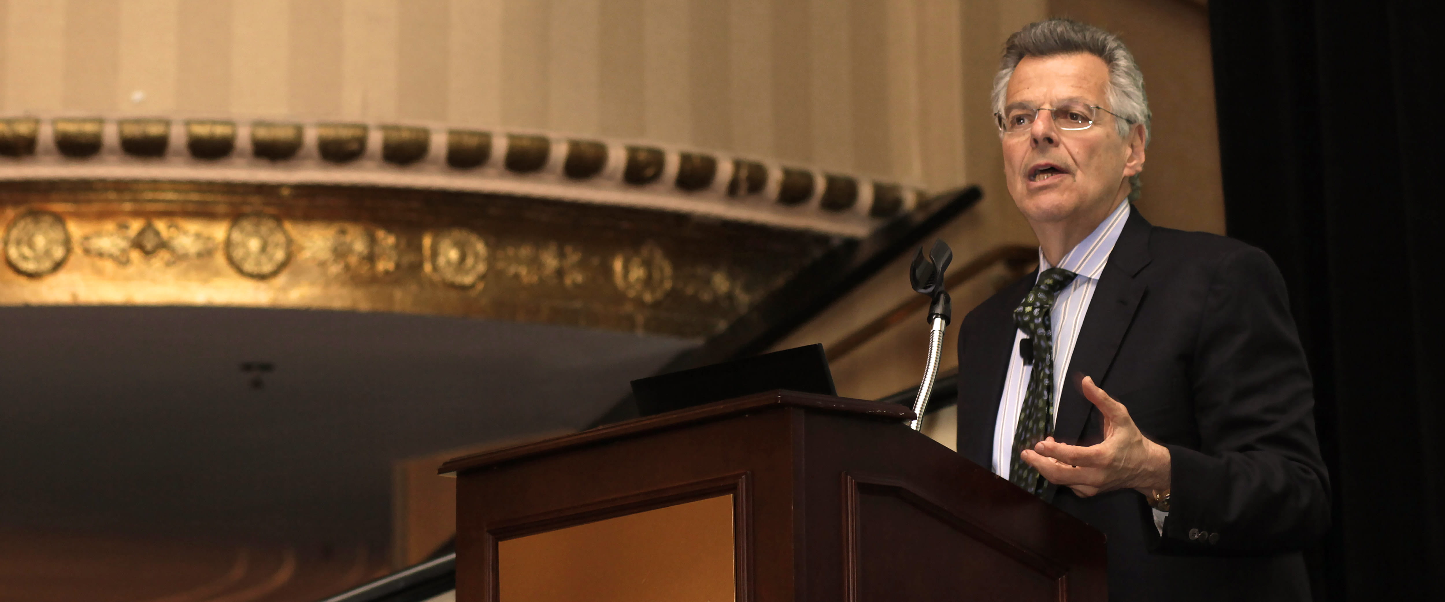 Myron Scholes speaking at a podium in an auditorium