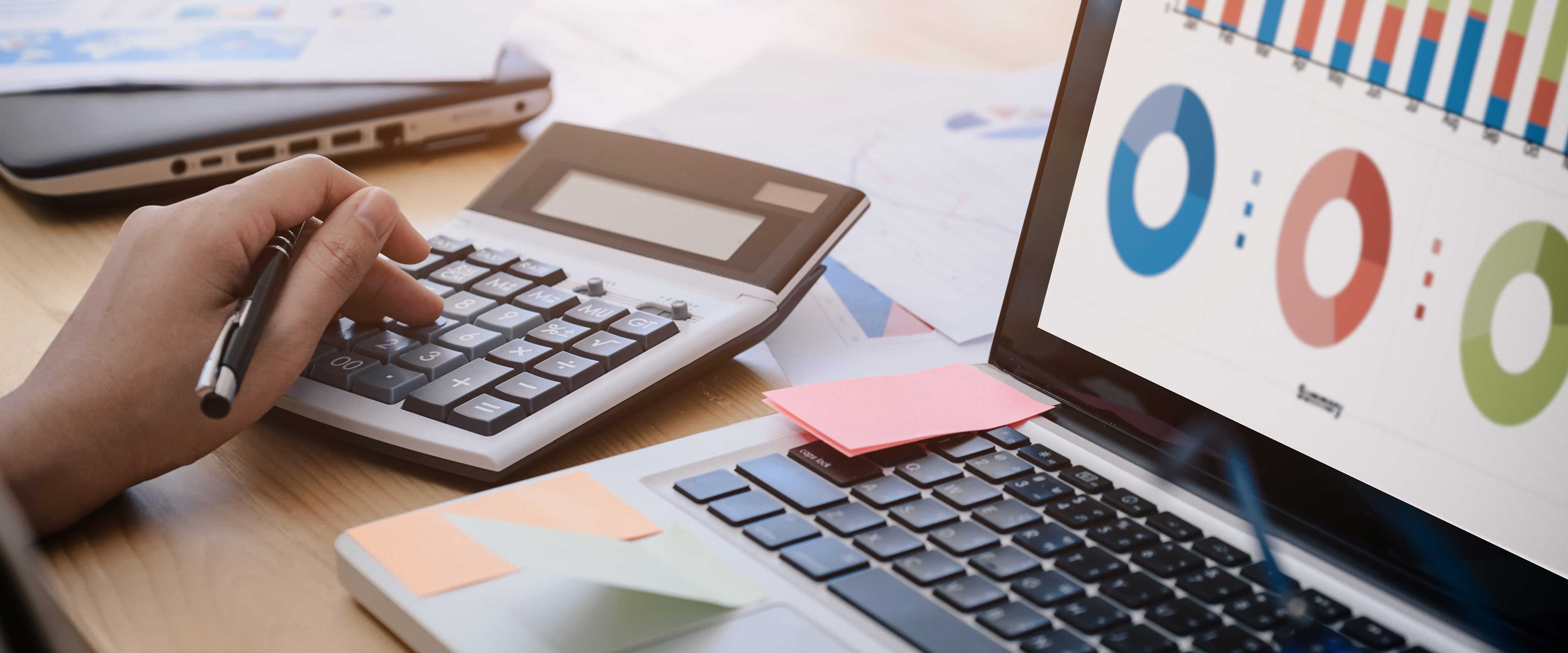 Person using a calculator and laptop