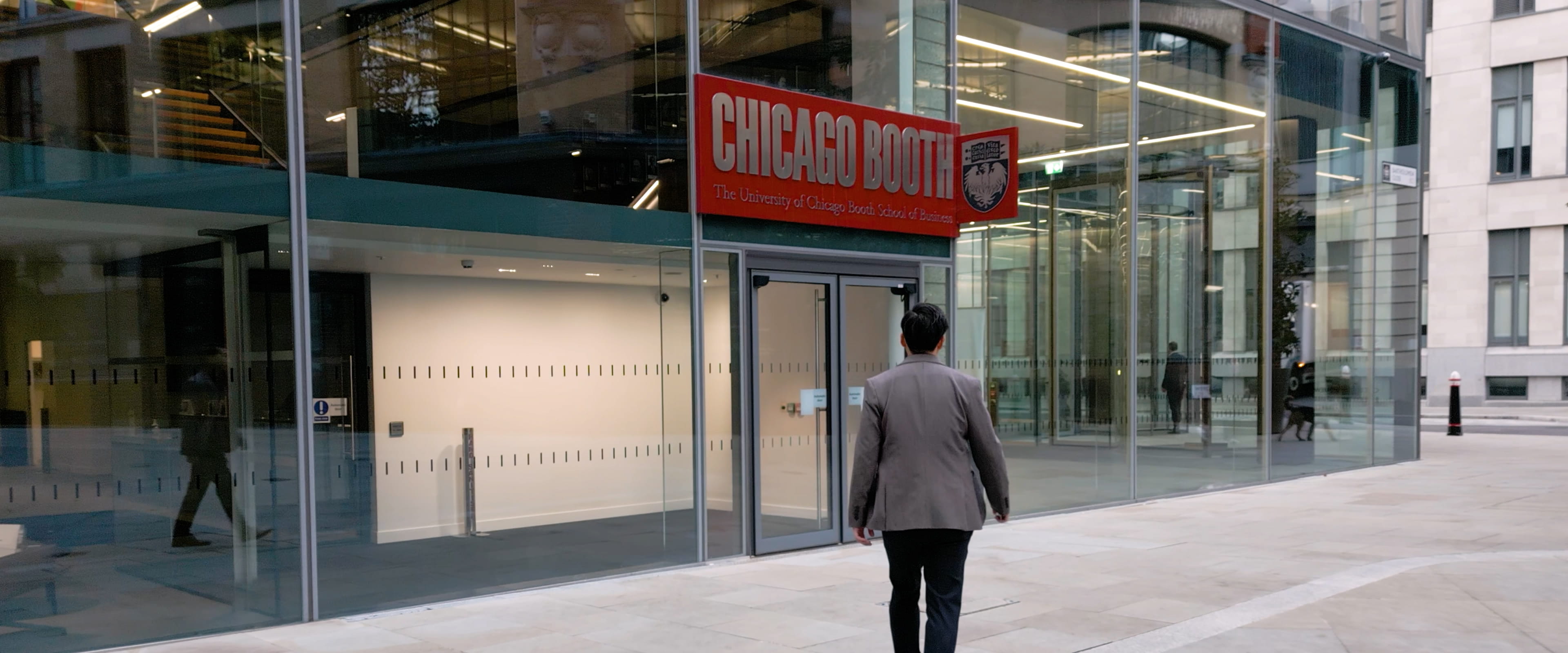 A person walking toward a Chicago Booth building.
