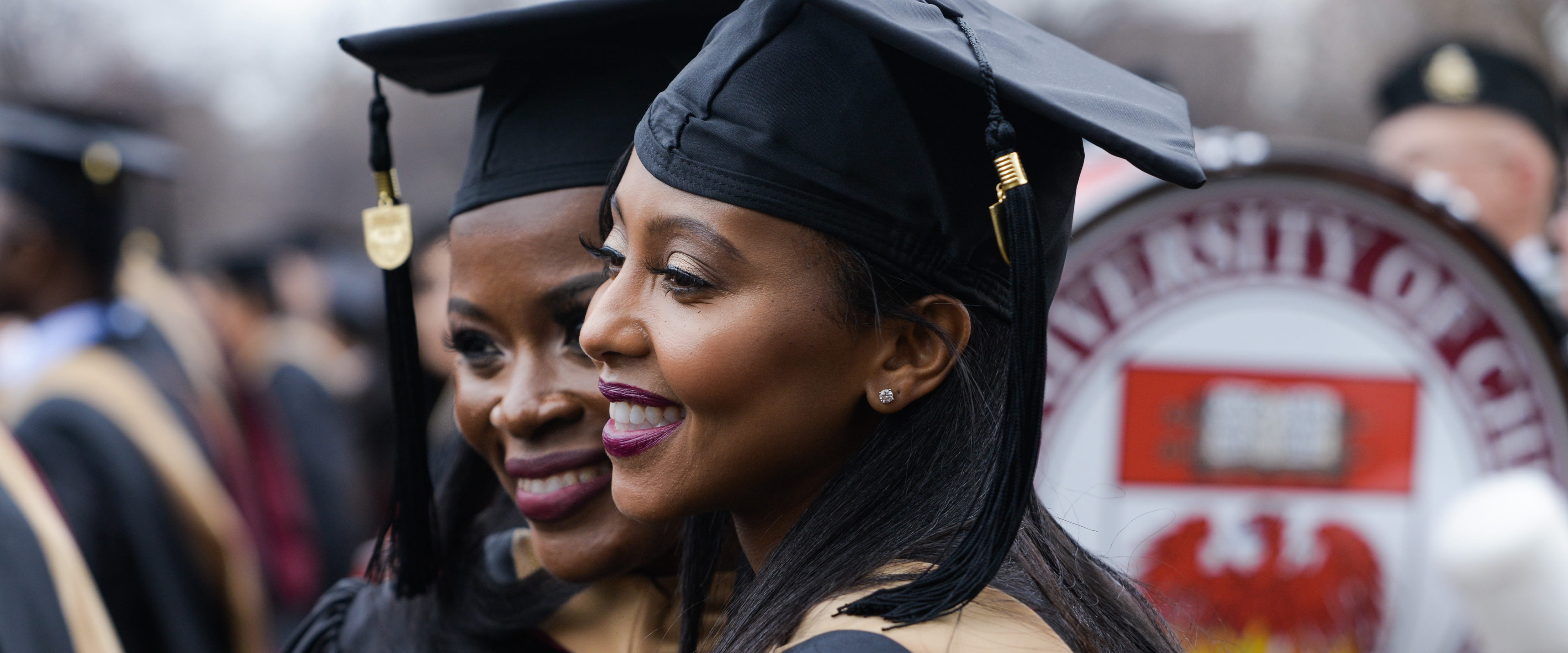 Students in caps and gowns smiling