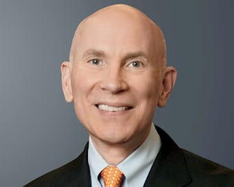 Headshot of Rob Kennedy, President and Co-CEO of C-Span, smiling at the camera on a simple gray background.