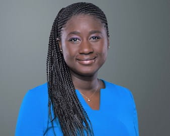 Black and white headshot of Adja Diakité, ’18 (EXP-23) in front of a gray background