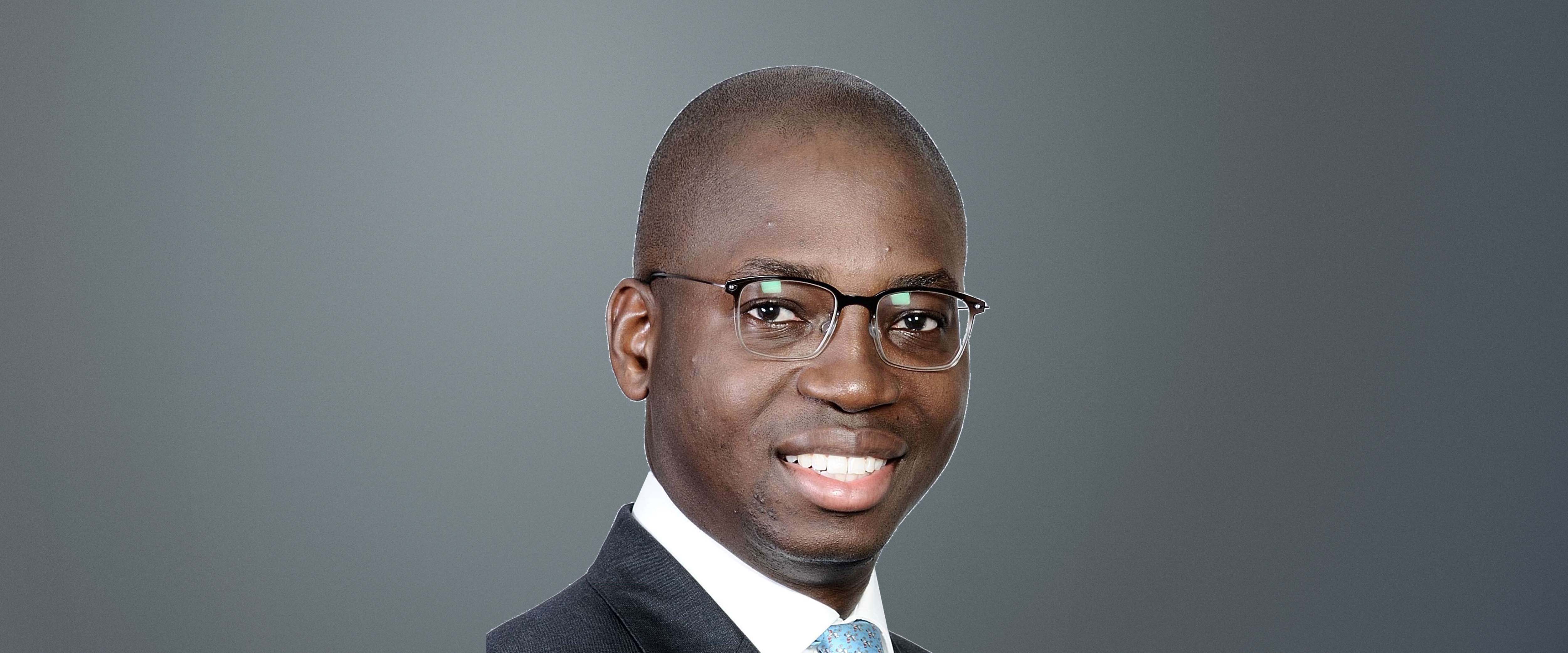 Black and white headshot of Funso Akere, ’15 (EXP-20) in front of a gray background