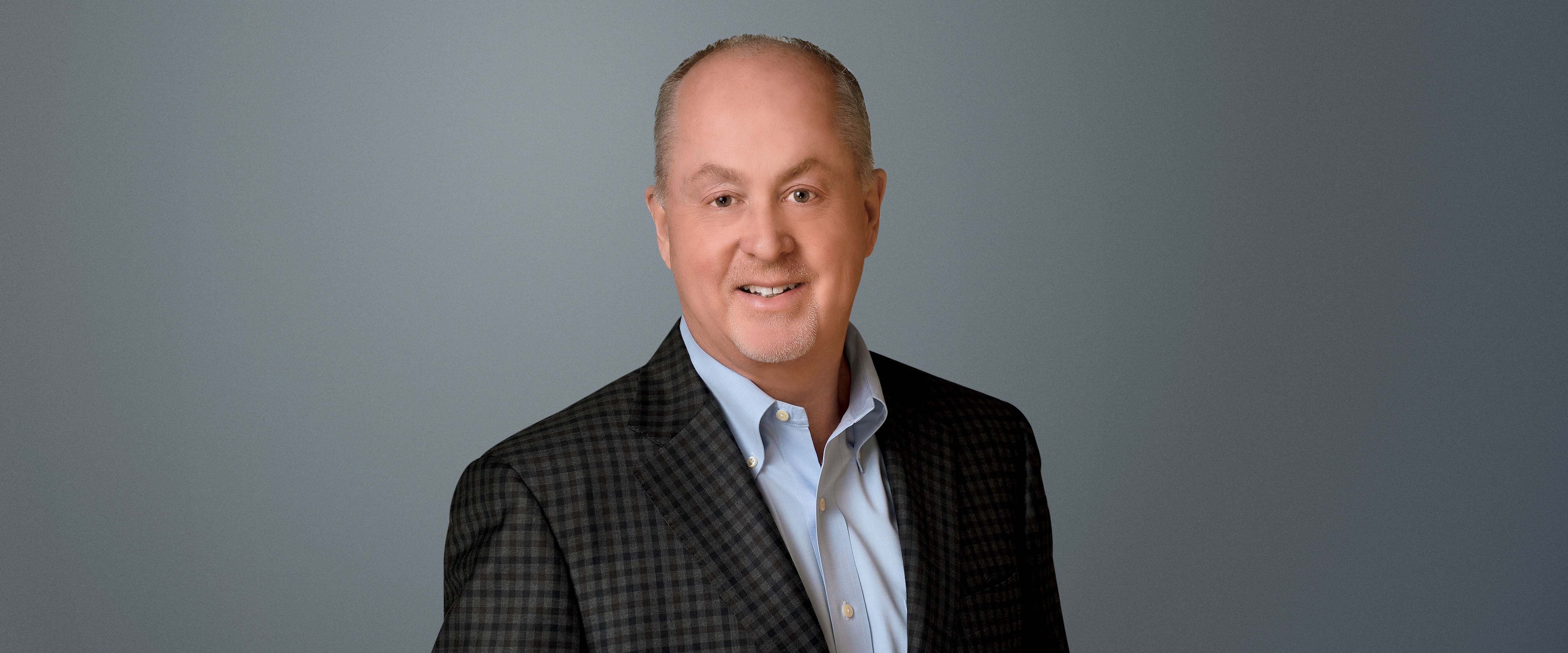 Headshot of Tyler Rose in front of a gray background