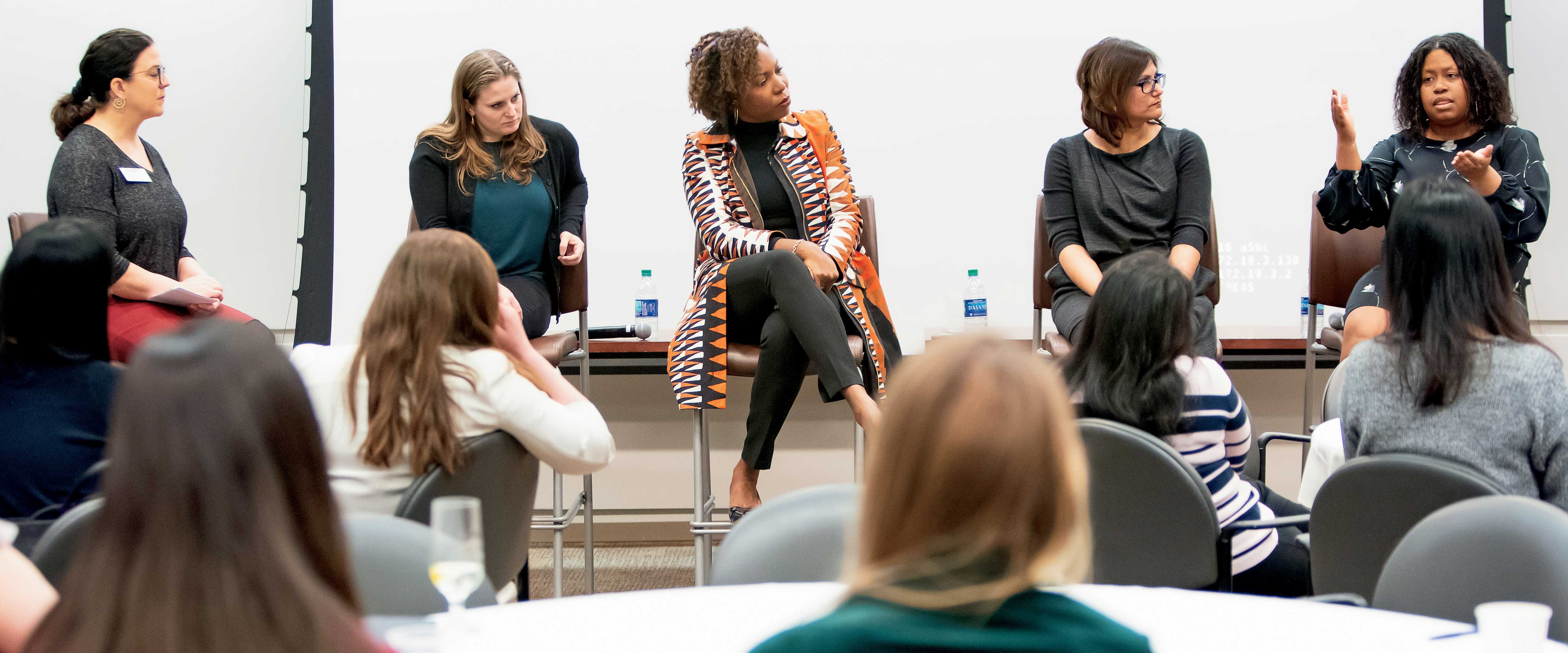 A group of women on the dias speaking at Booth's first international women's day conference