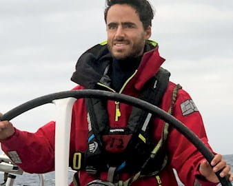 Chicago Booth alumnus Juan Carlos Velasquez driving a sail boat