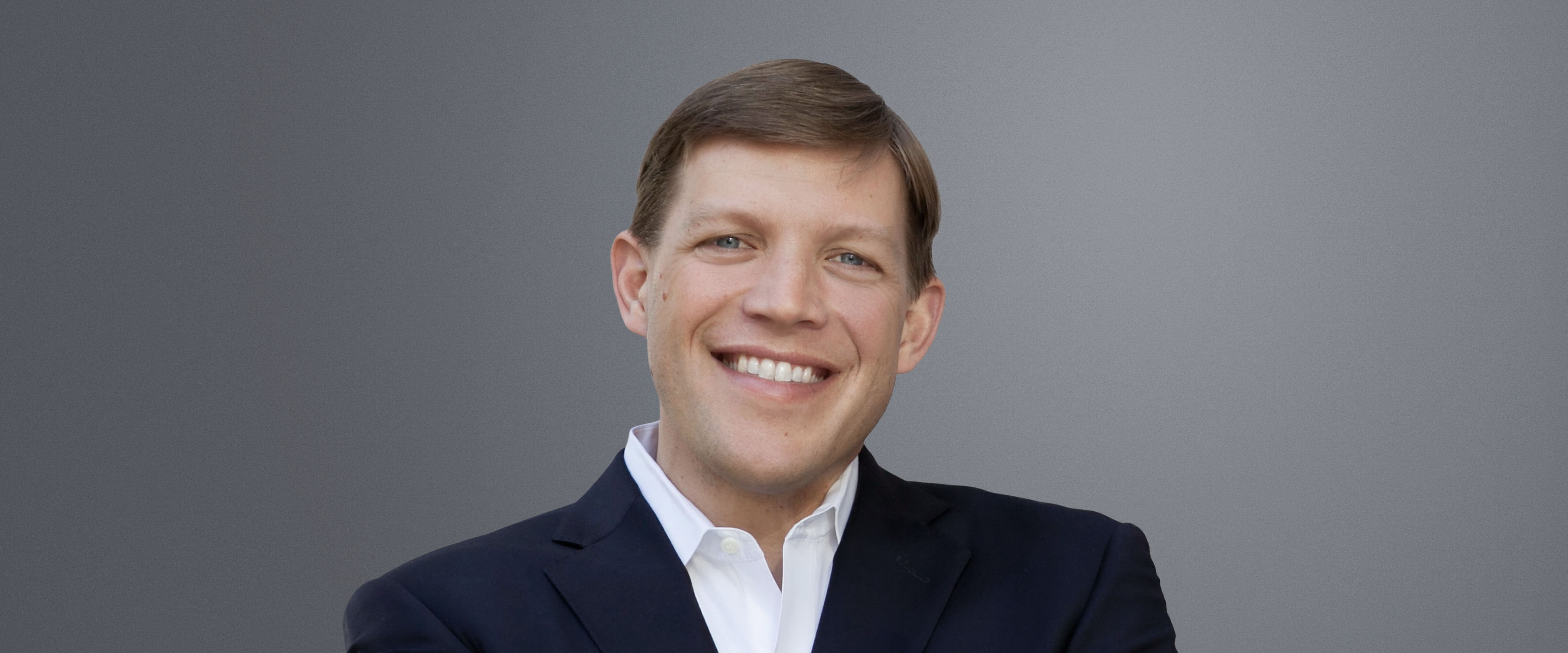 A headshot of Rev Peter Lane against a gray background