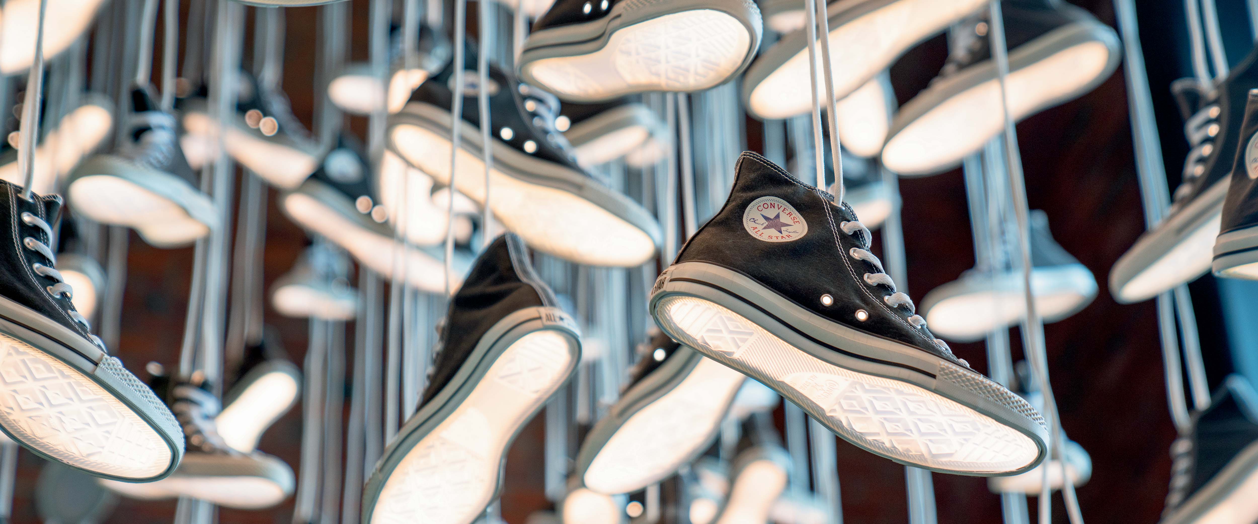 Many Converse shoes hanging by laces