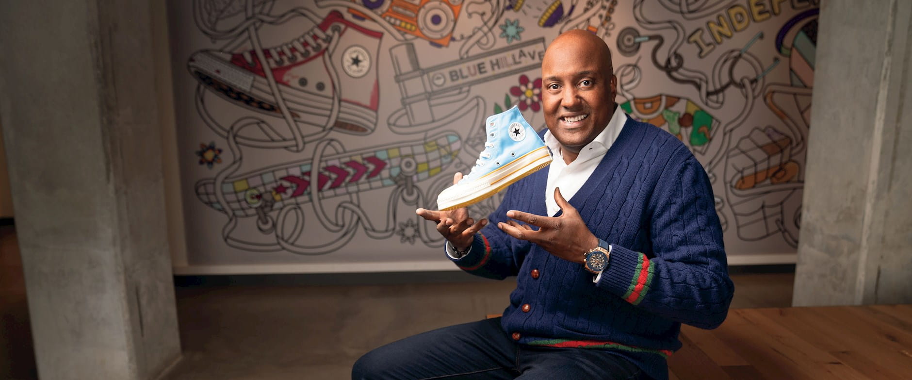 G. Scott Uzzell, CEO of Converse, smiling and holding a blue Converse shoe