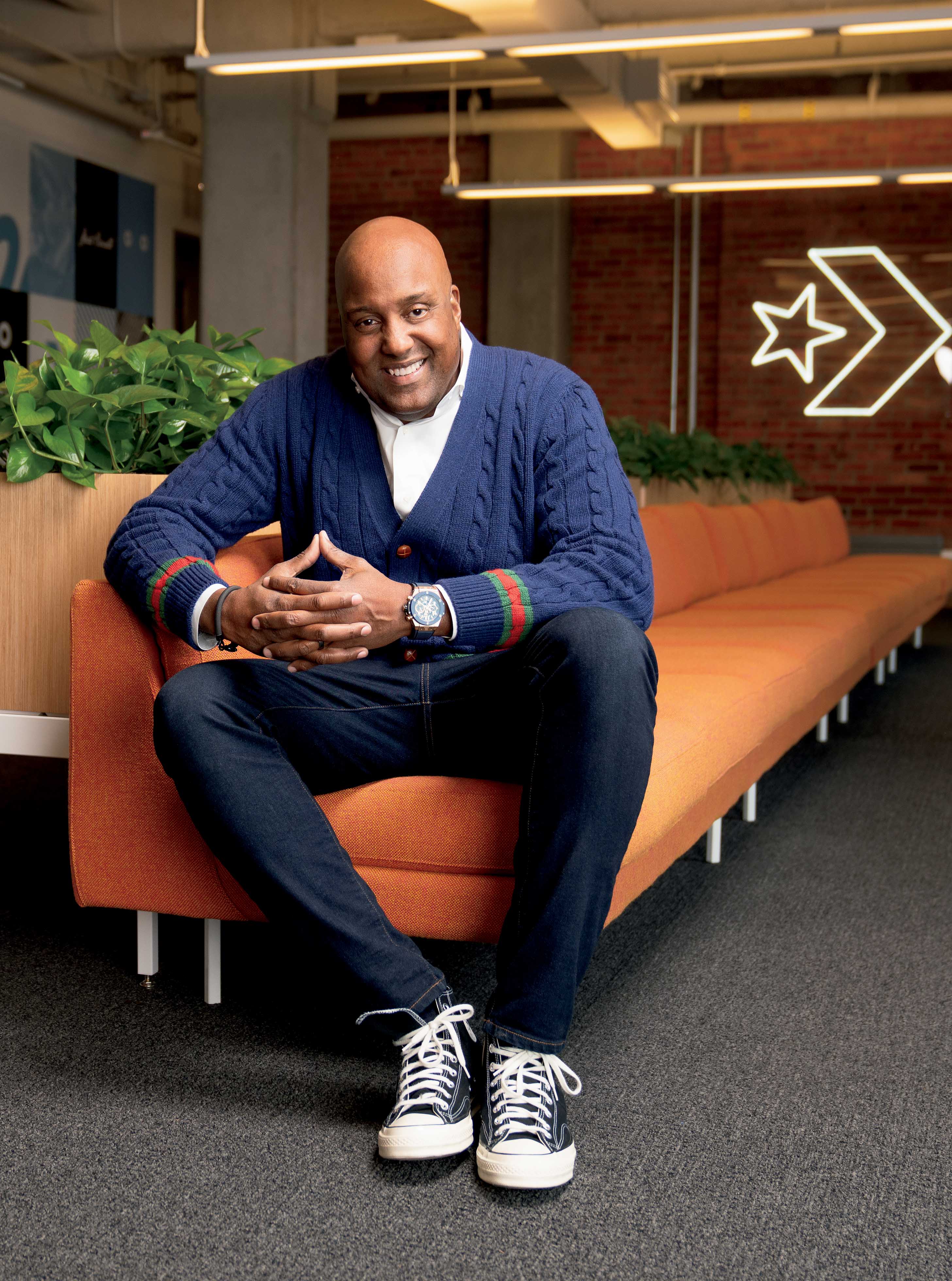 G. Scott Uzzell, CEO of Converse, sitting and smiling on an orange sofa