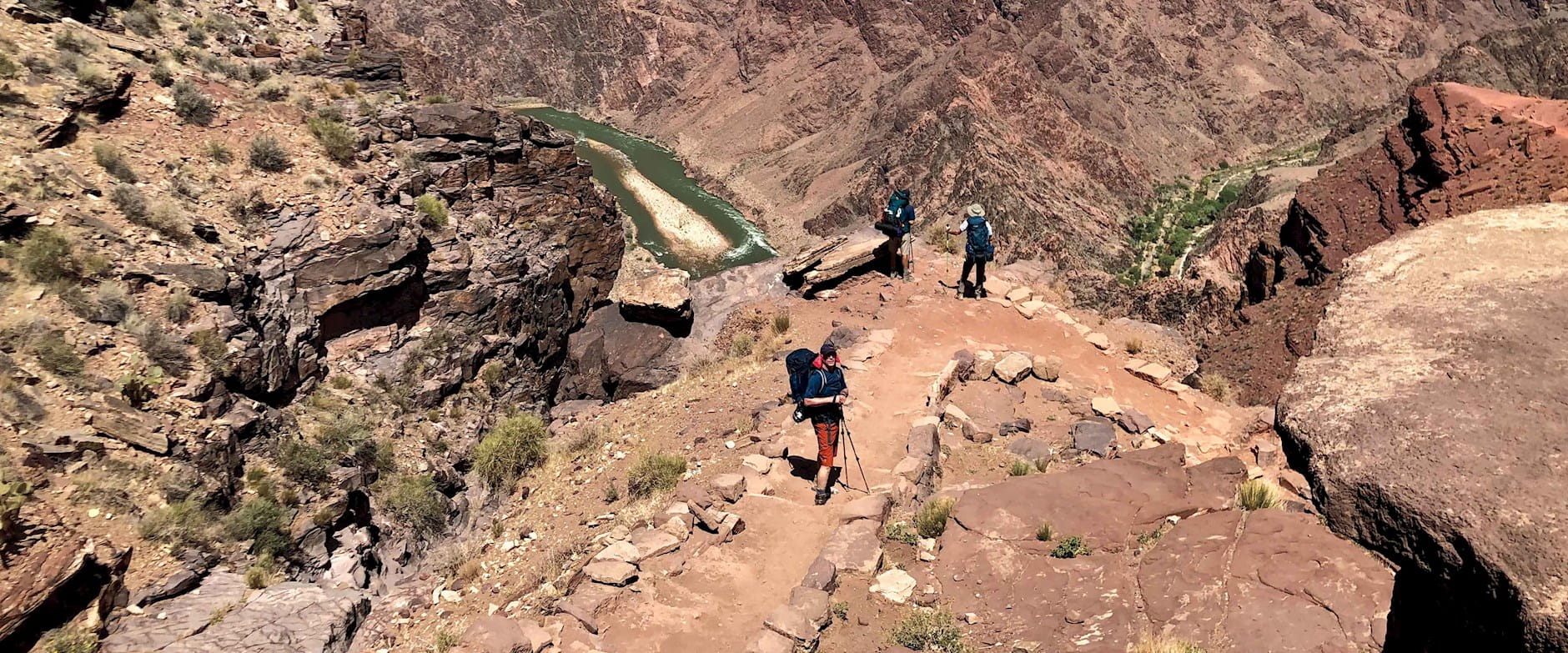 Several people hiking a trail on the Grand Canyon