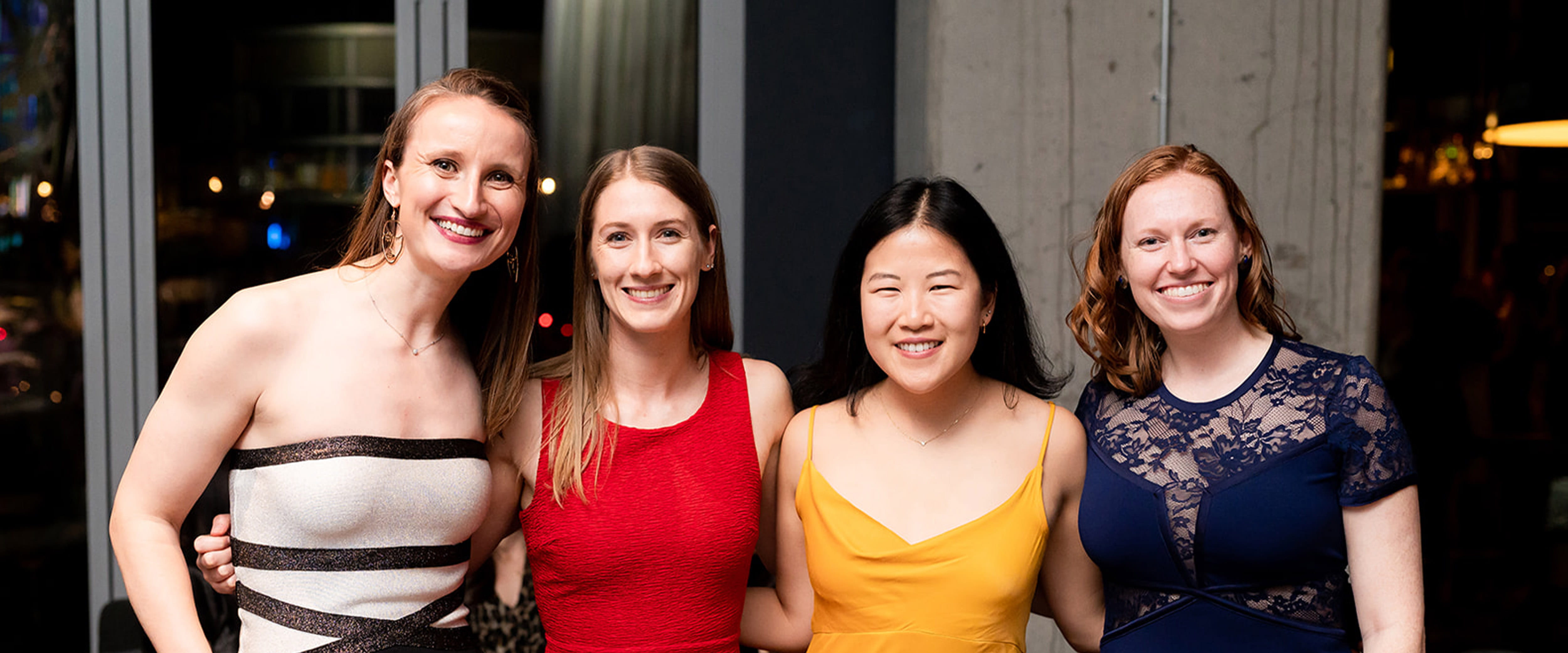Four friends including Melissa Chang posing in formal attire