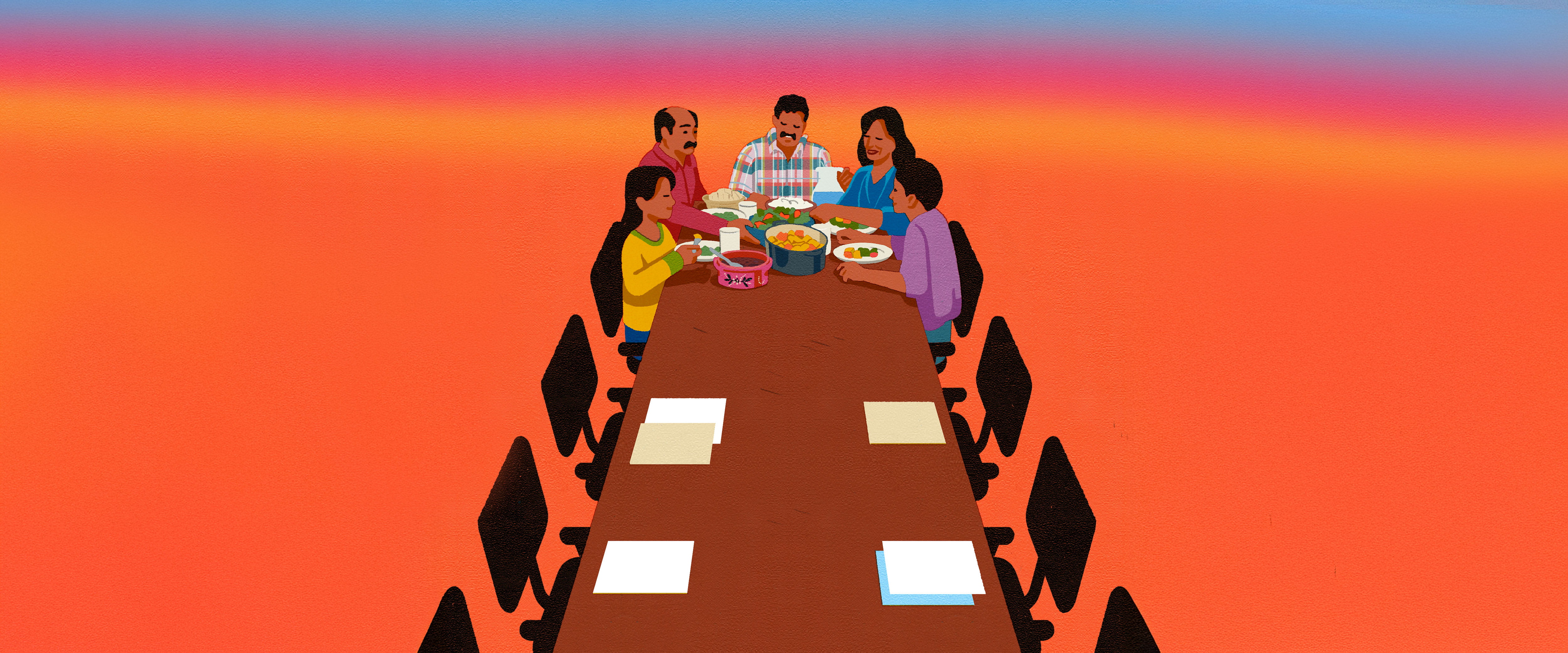 Family eating together at the end of long table that is half empty