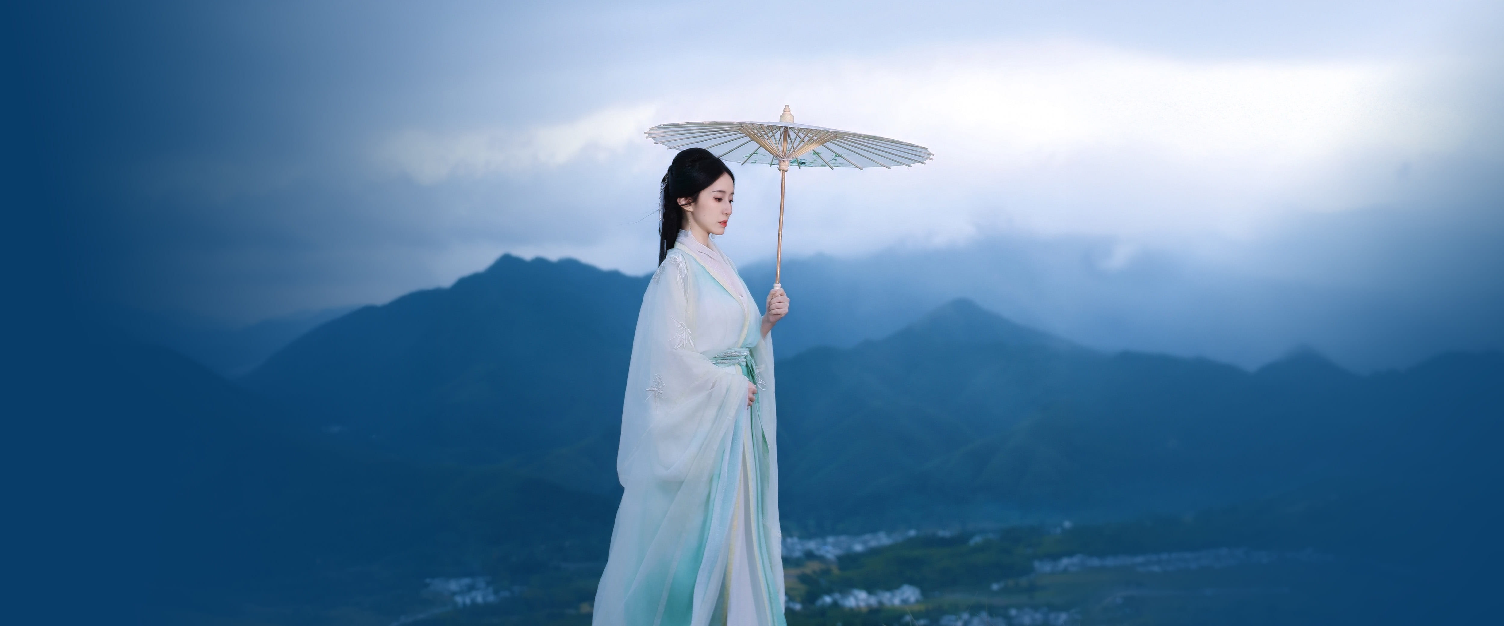 Jean Zhou walking in traditional clothing holding an umbrella
