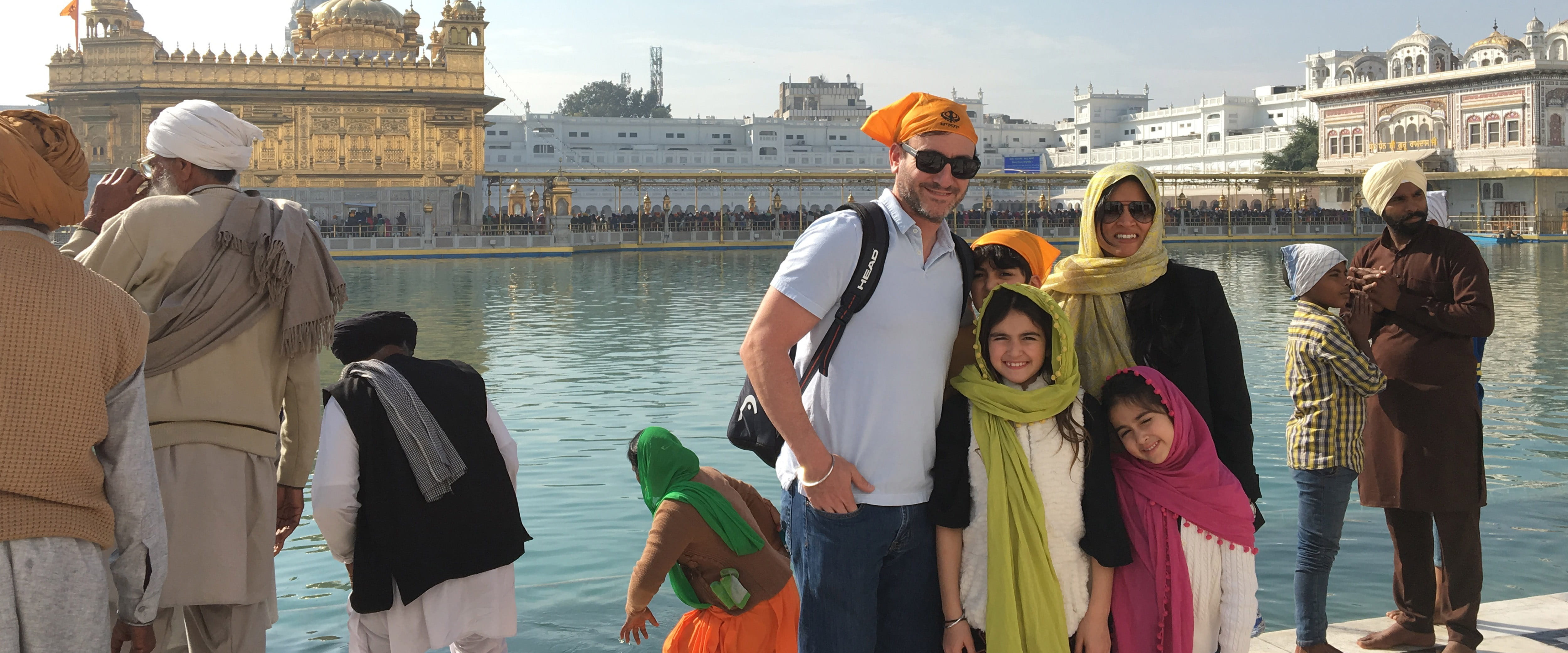 Levin and his family in front of a river and palace in India.