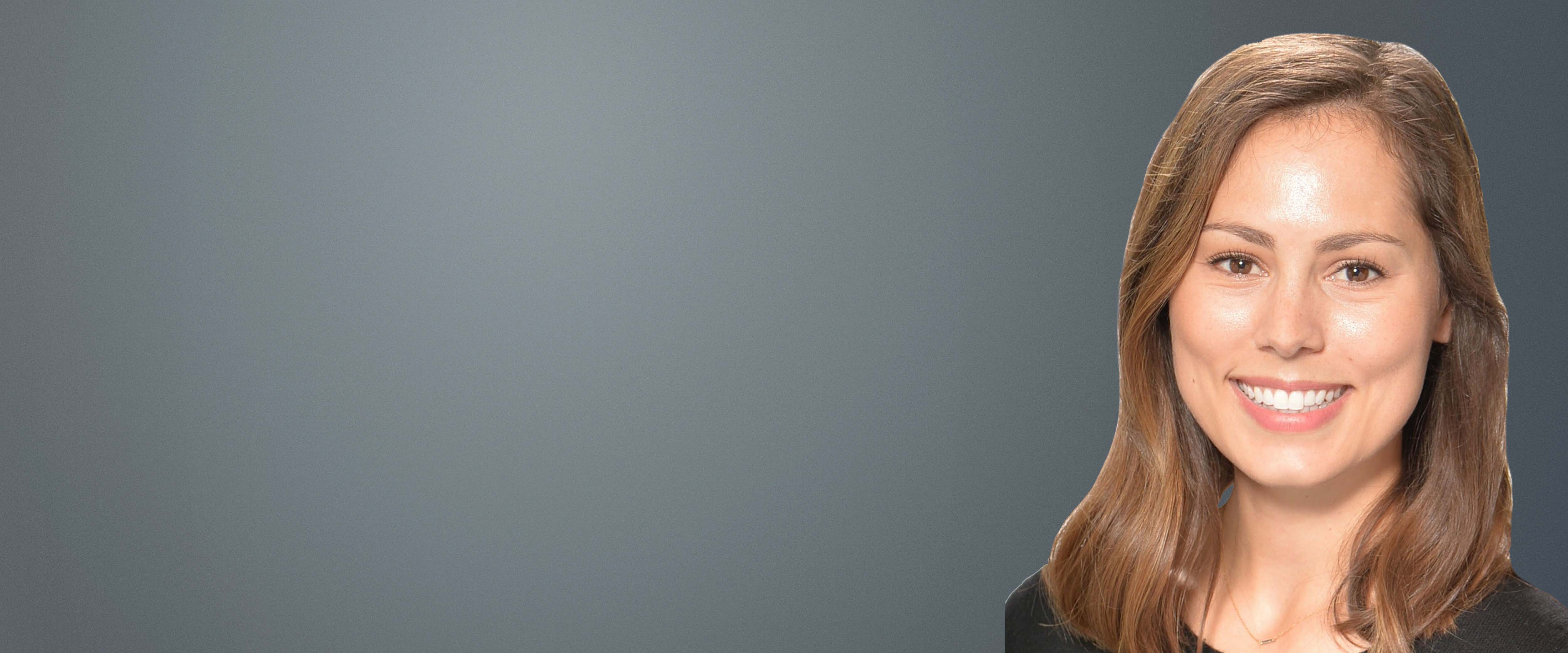 Black and white headshot of Emily Welch in front of a gray background 