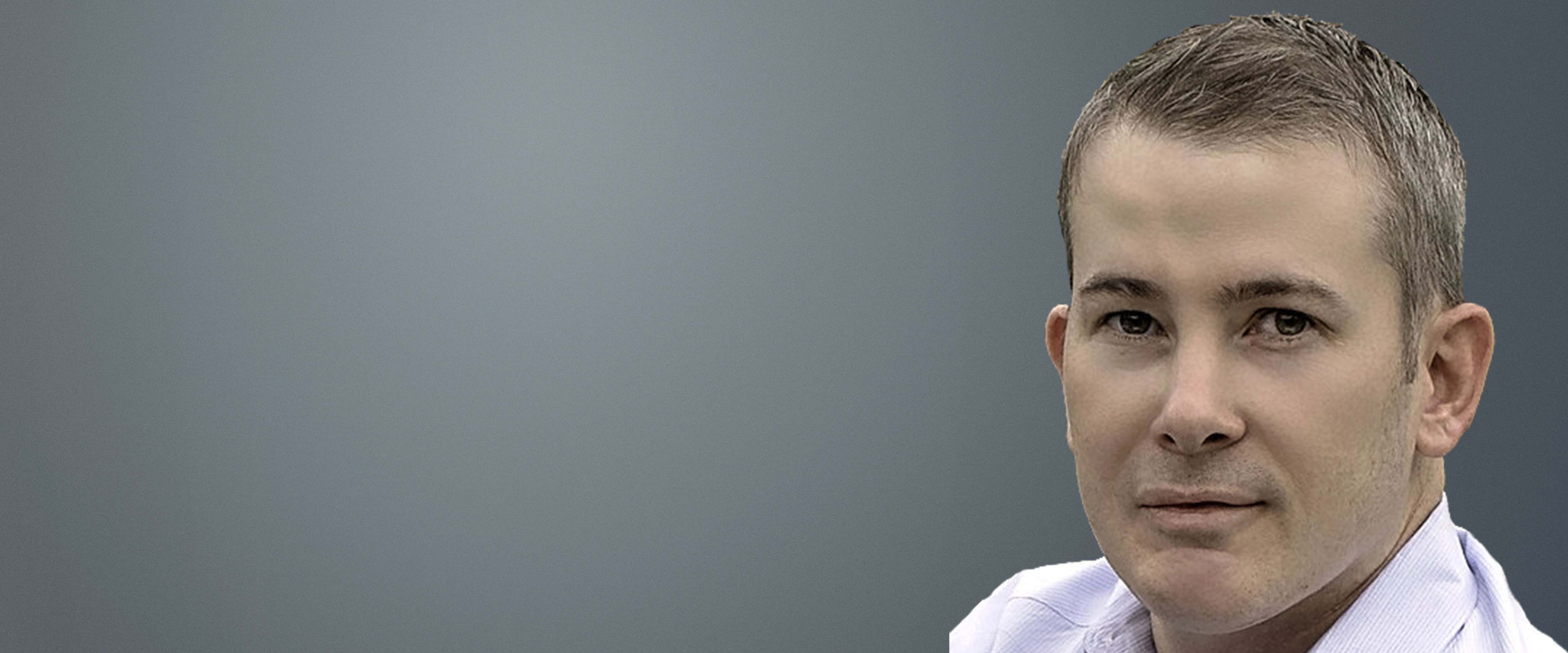 Black and white headshot of Mike Kinder in front of a gray background 