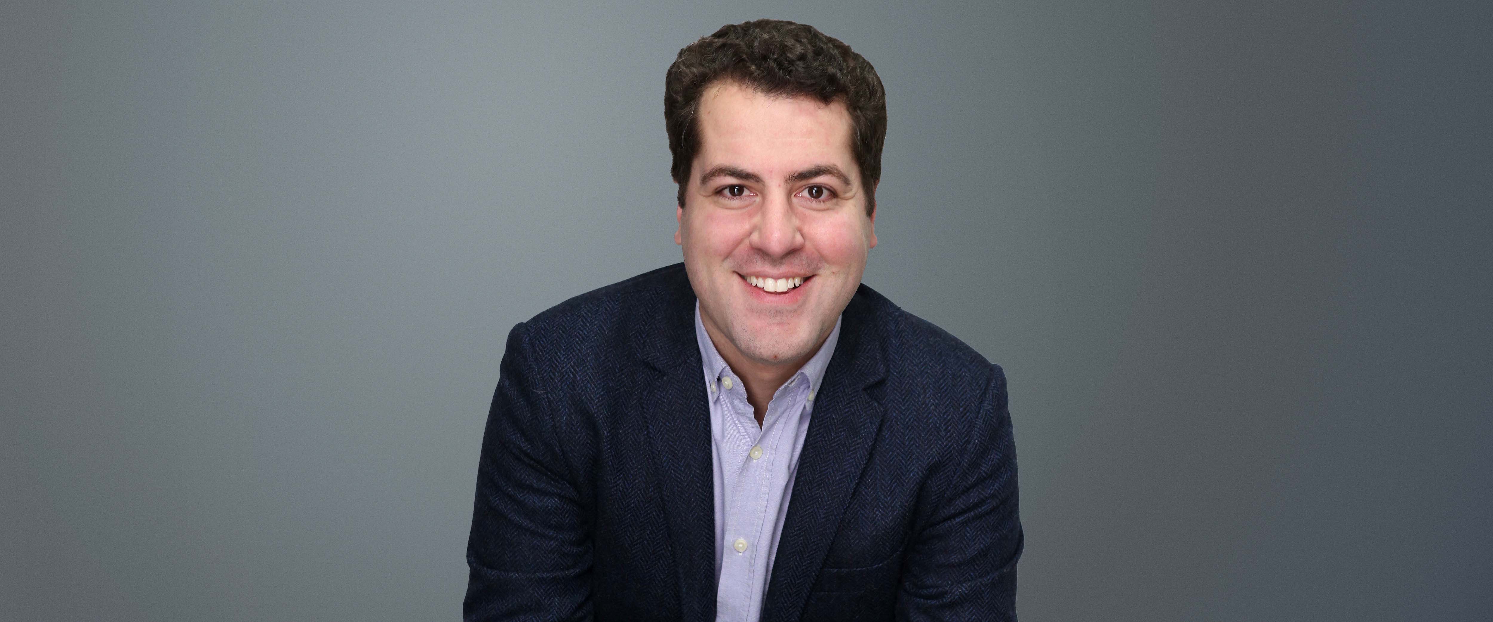 Black and white headshot of Ricardo Taveira in front of a gray background 