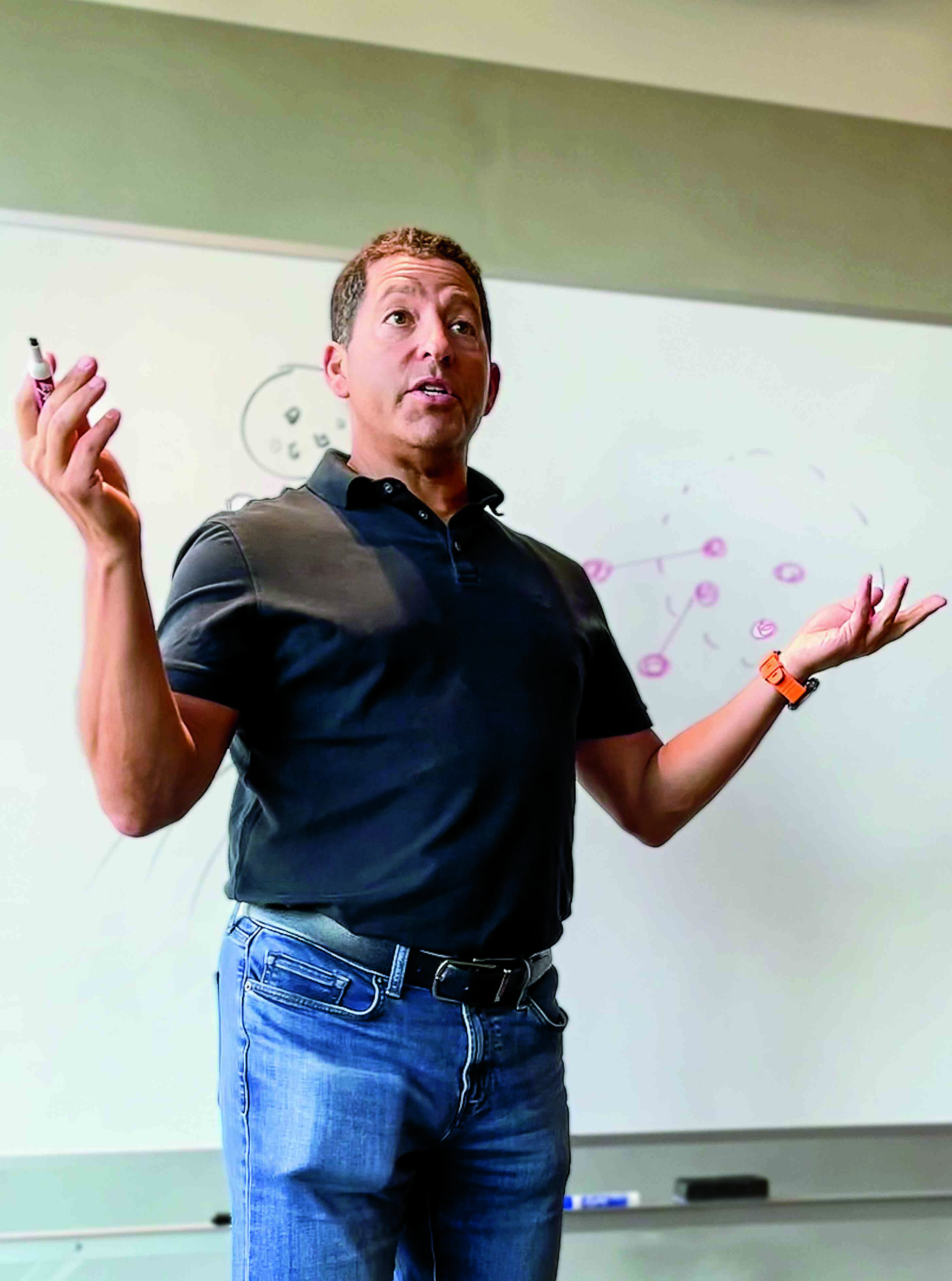 Jordan Waxman lecturing in front of whiteboard