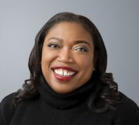 Melinda Hightower smiling in front of gray background