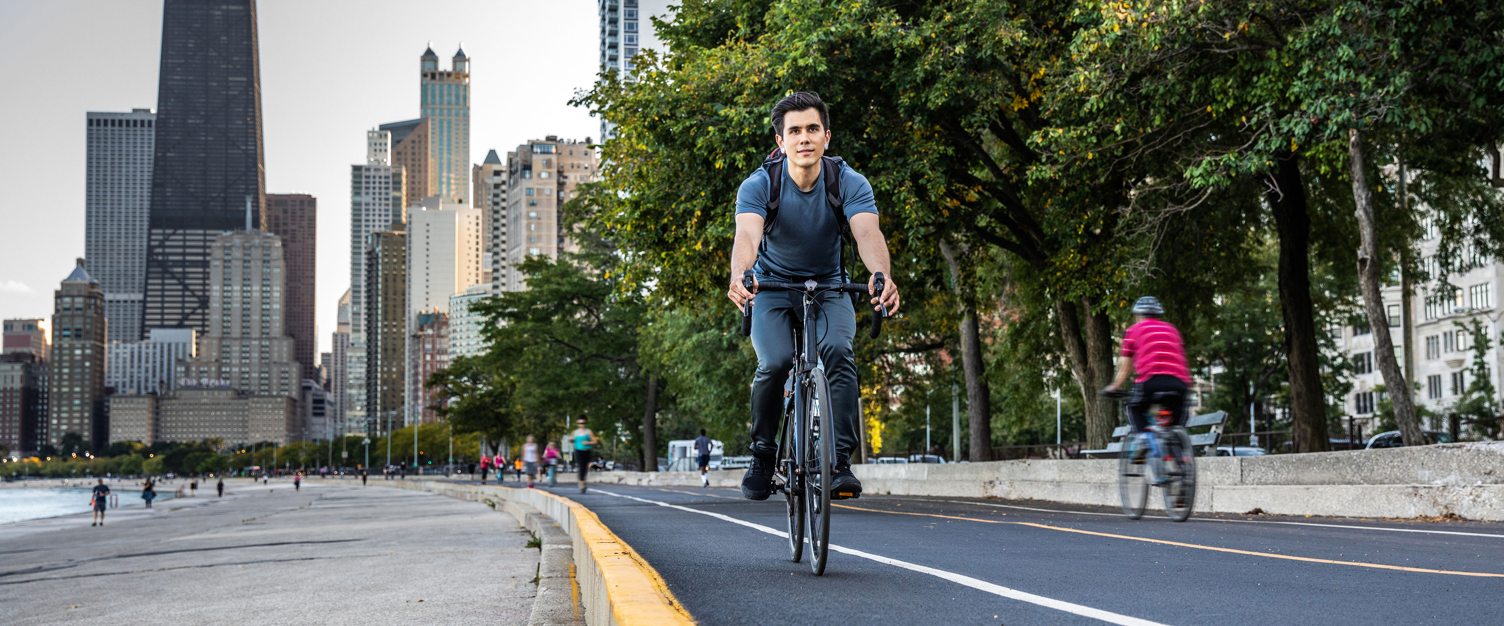 Man biking on lakefront with Chicago in background