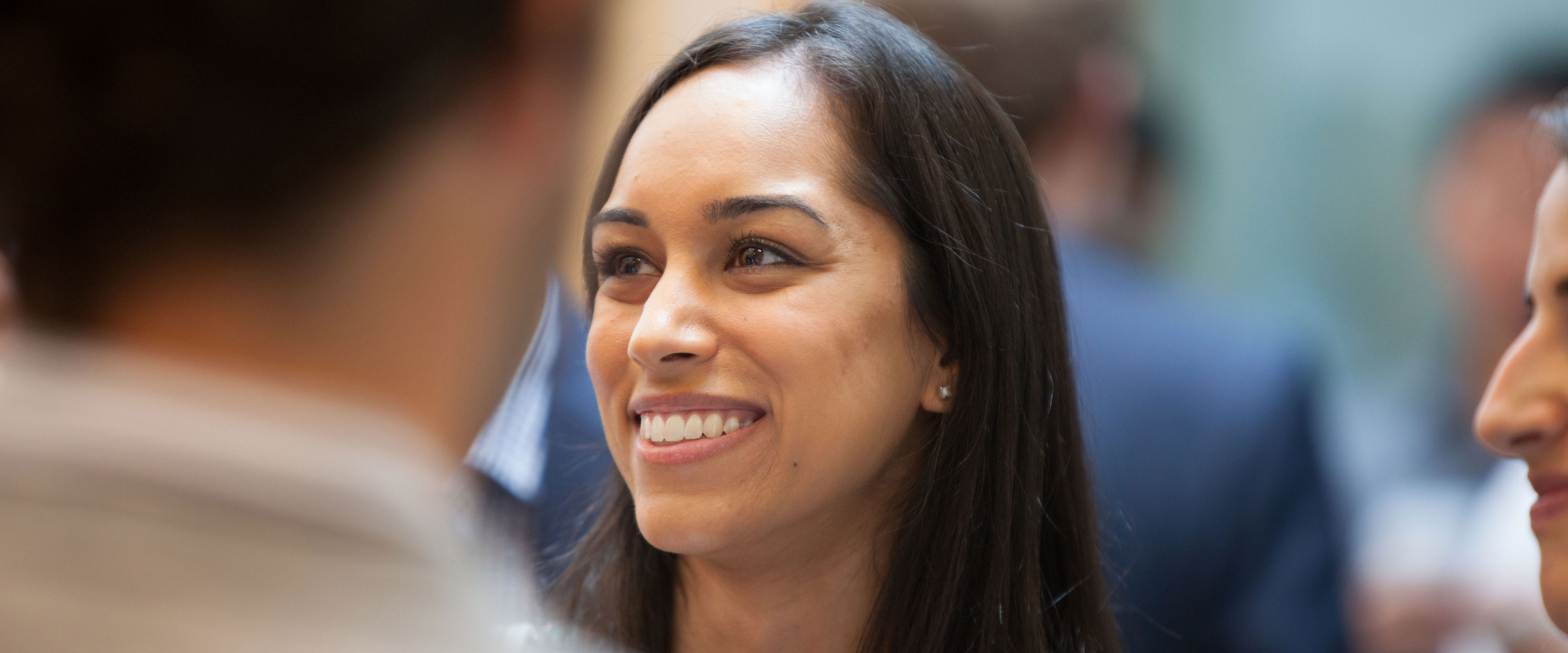 Female alumna smiling and listening