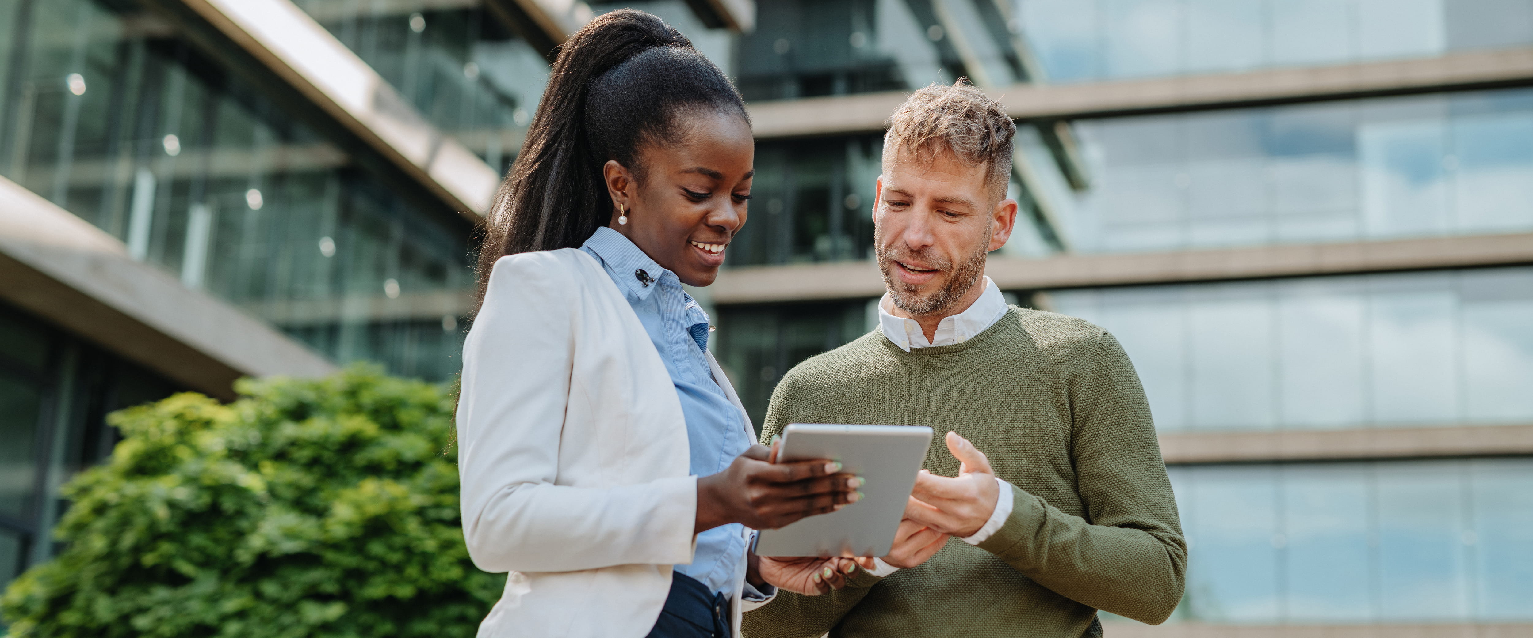 Two people looking at an iPad. 