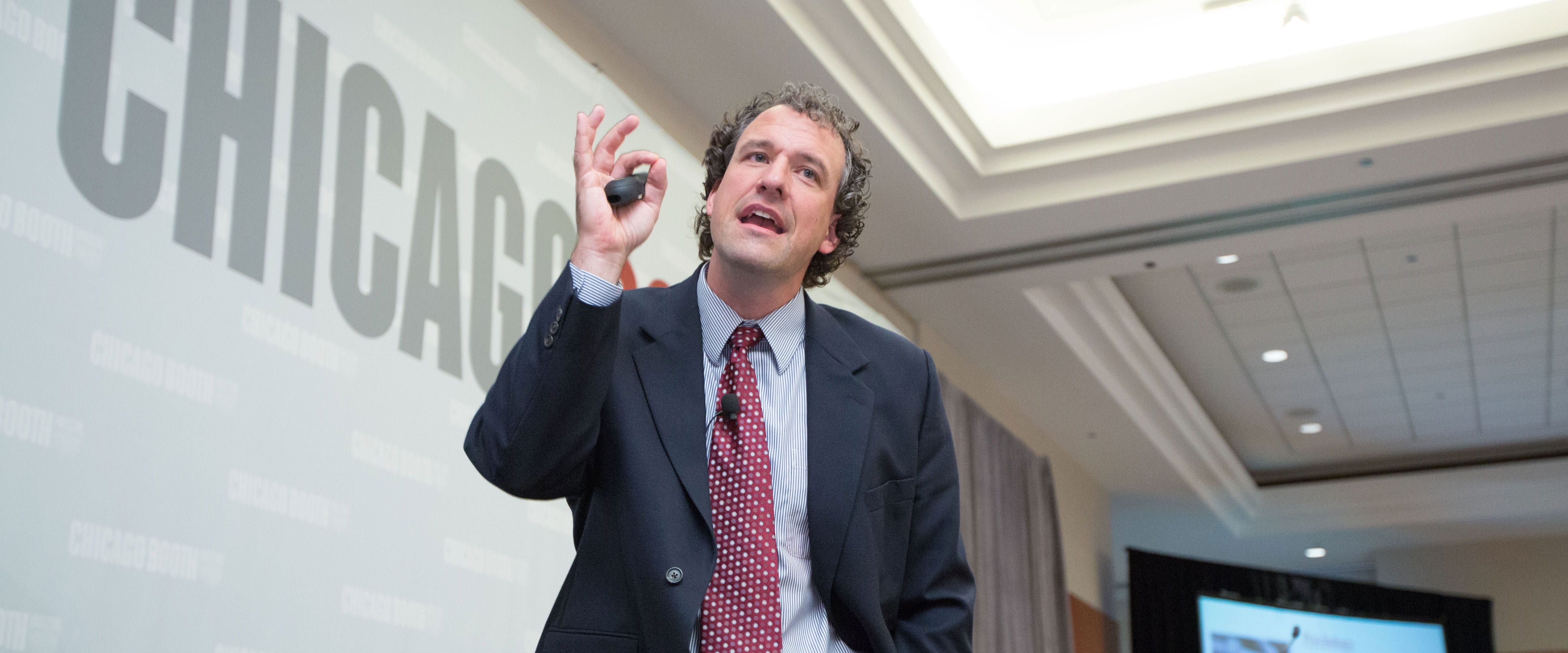 Professor Nicholas Epley speaking and holding a remote