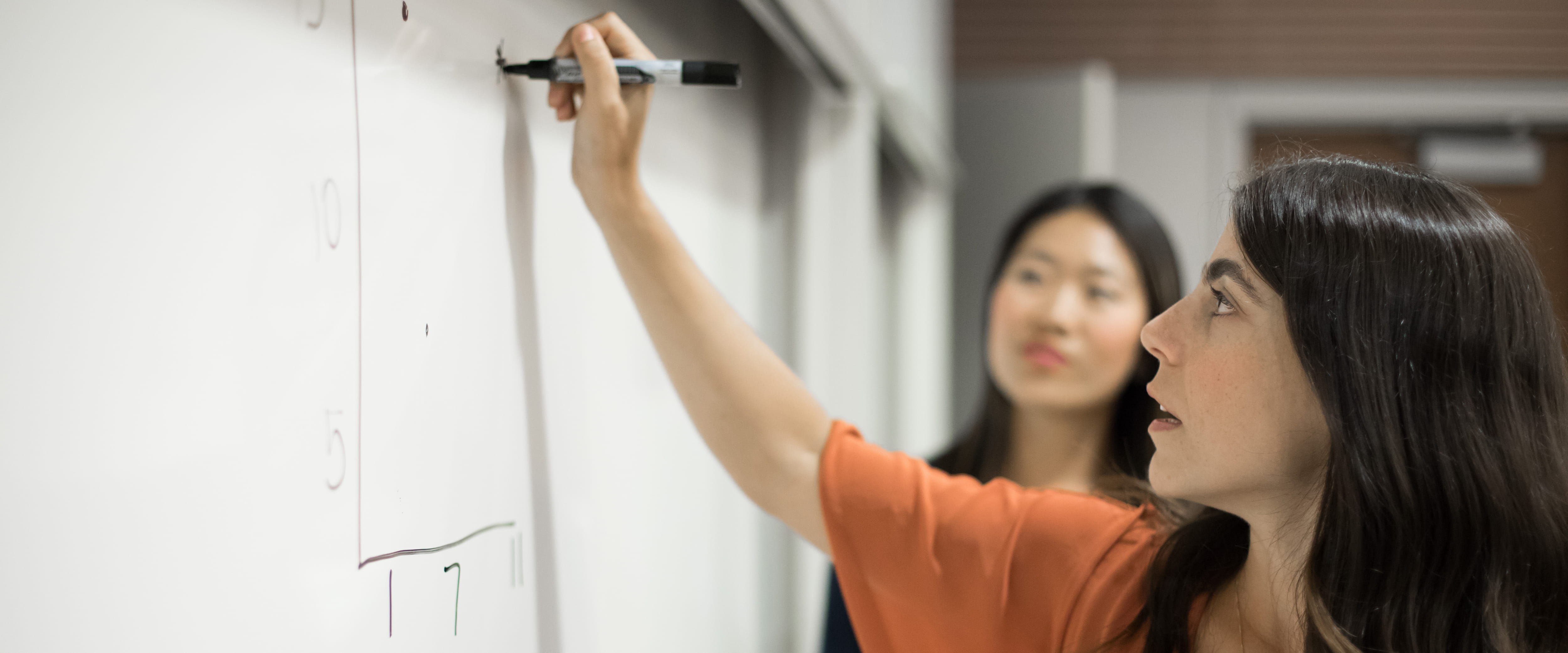 Female student writing on a whiteboard