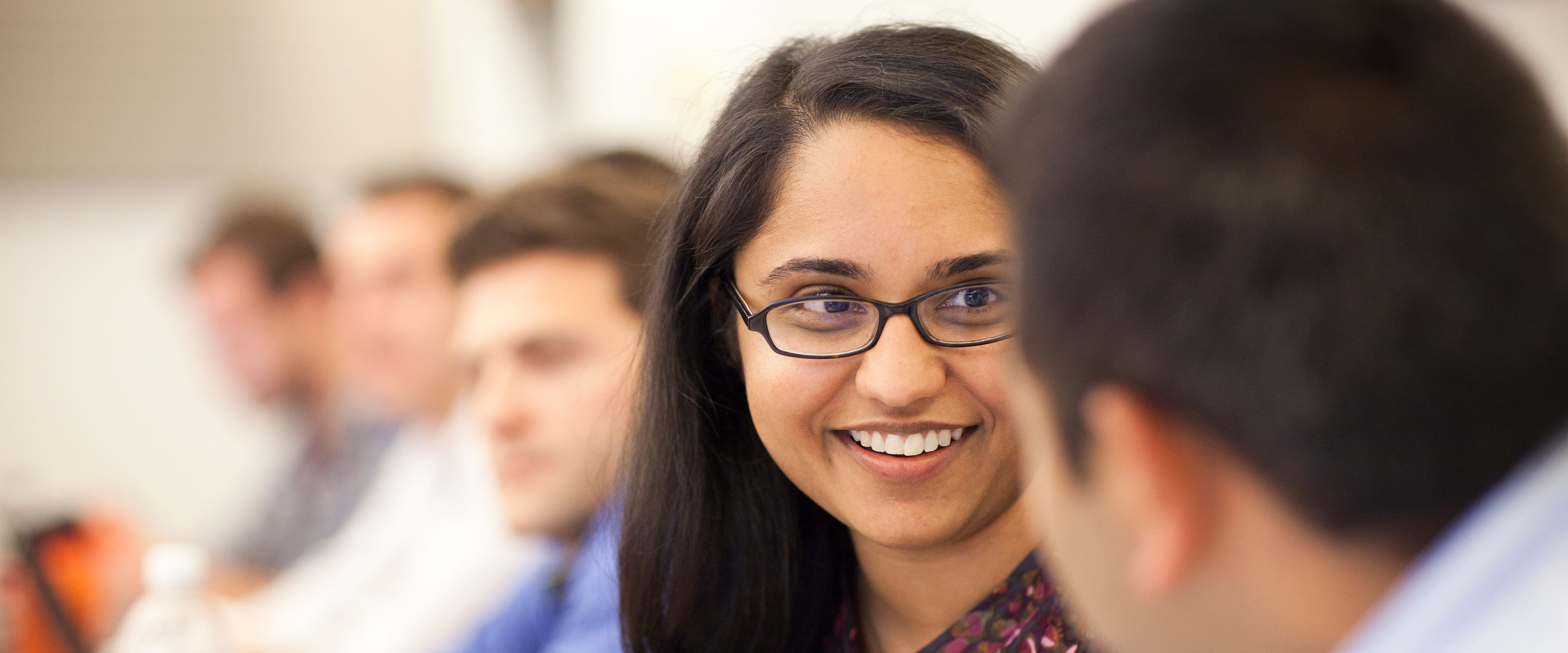 Female student in class, in conversation with colleague