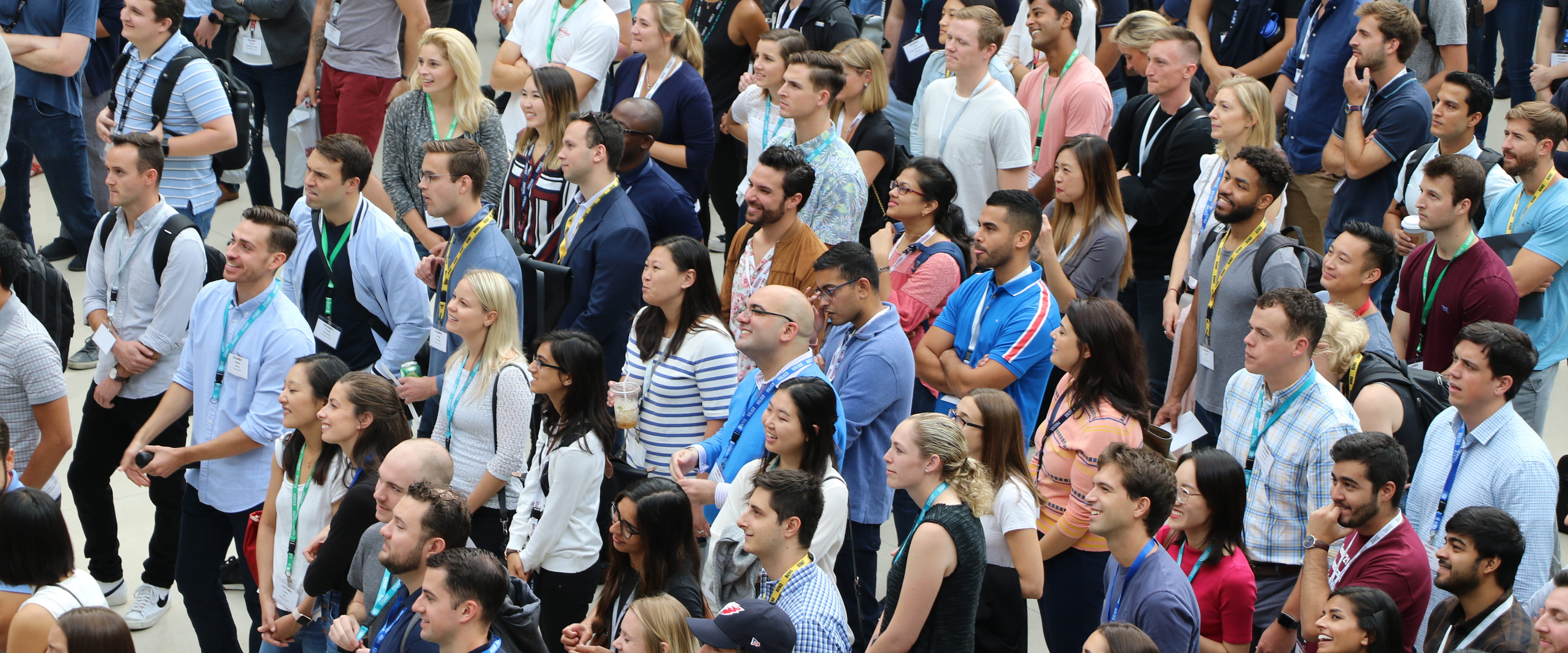 Chicago Booth students stand together, listening to speaker on orientation day