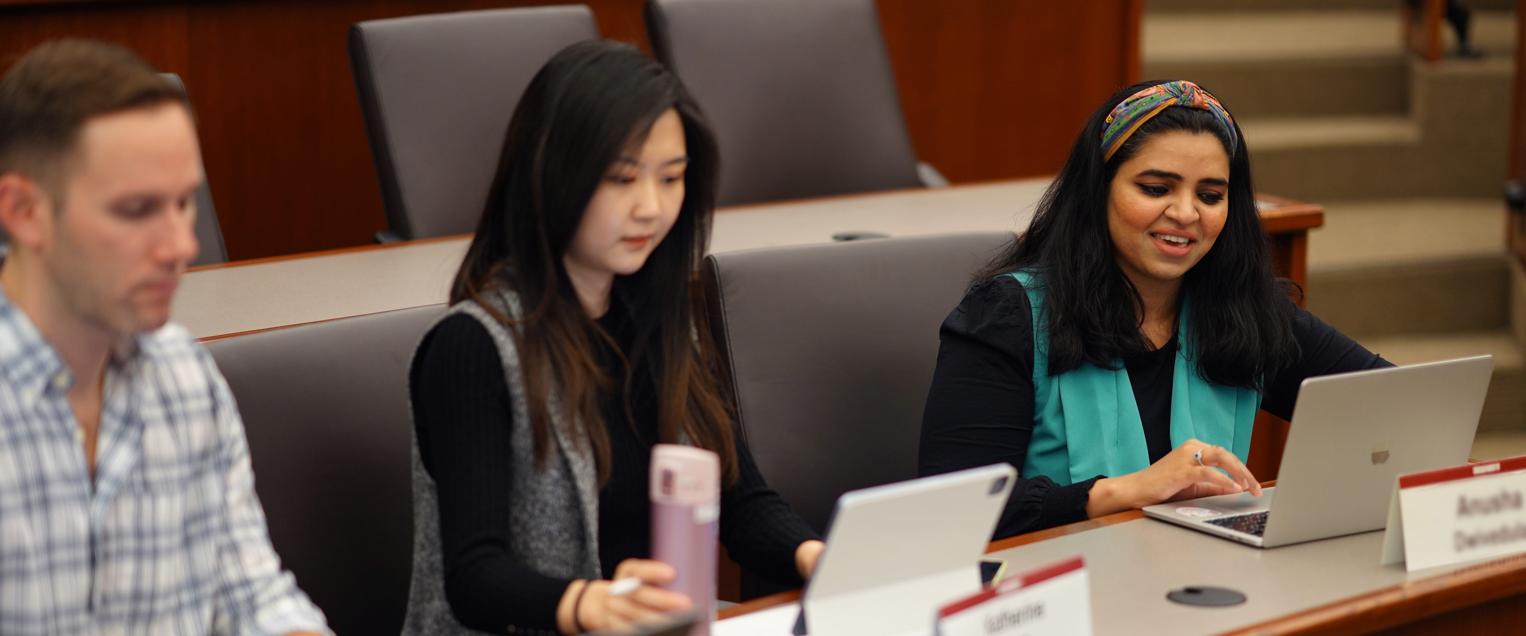 Three students collaborating together in a classroom