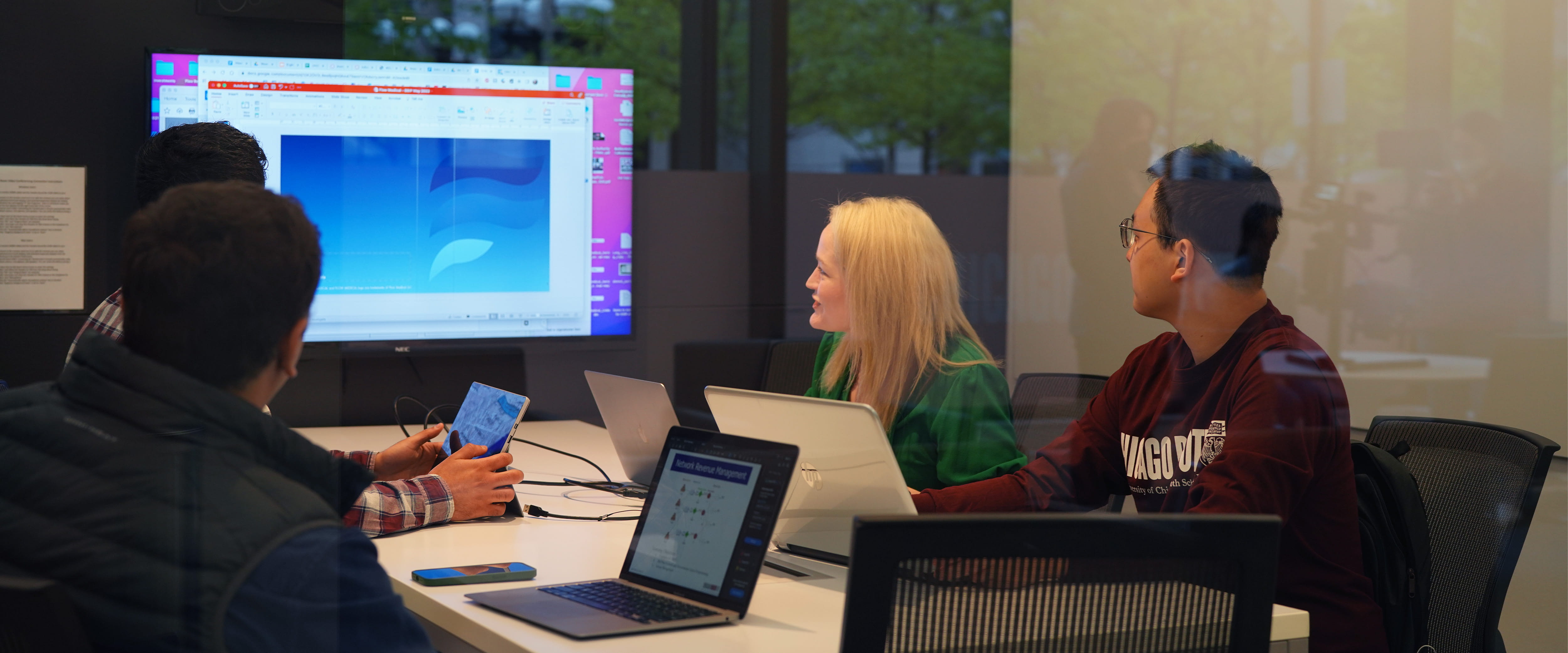 Group of people at a conference table presenting