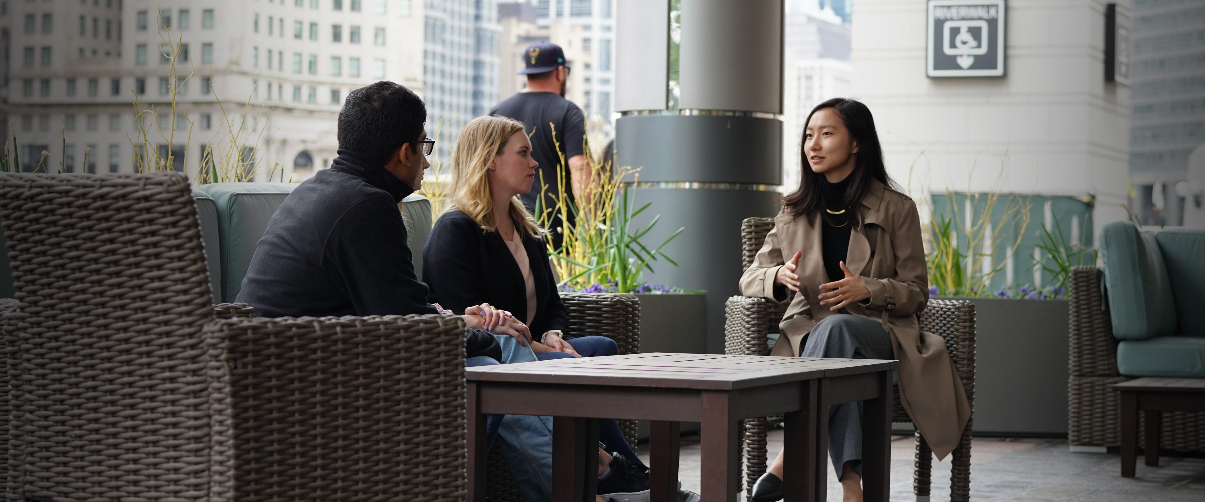 Three students chatting and networking outside Gleacher Center