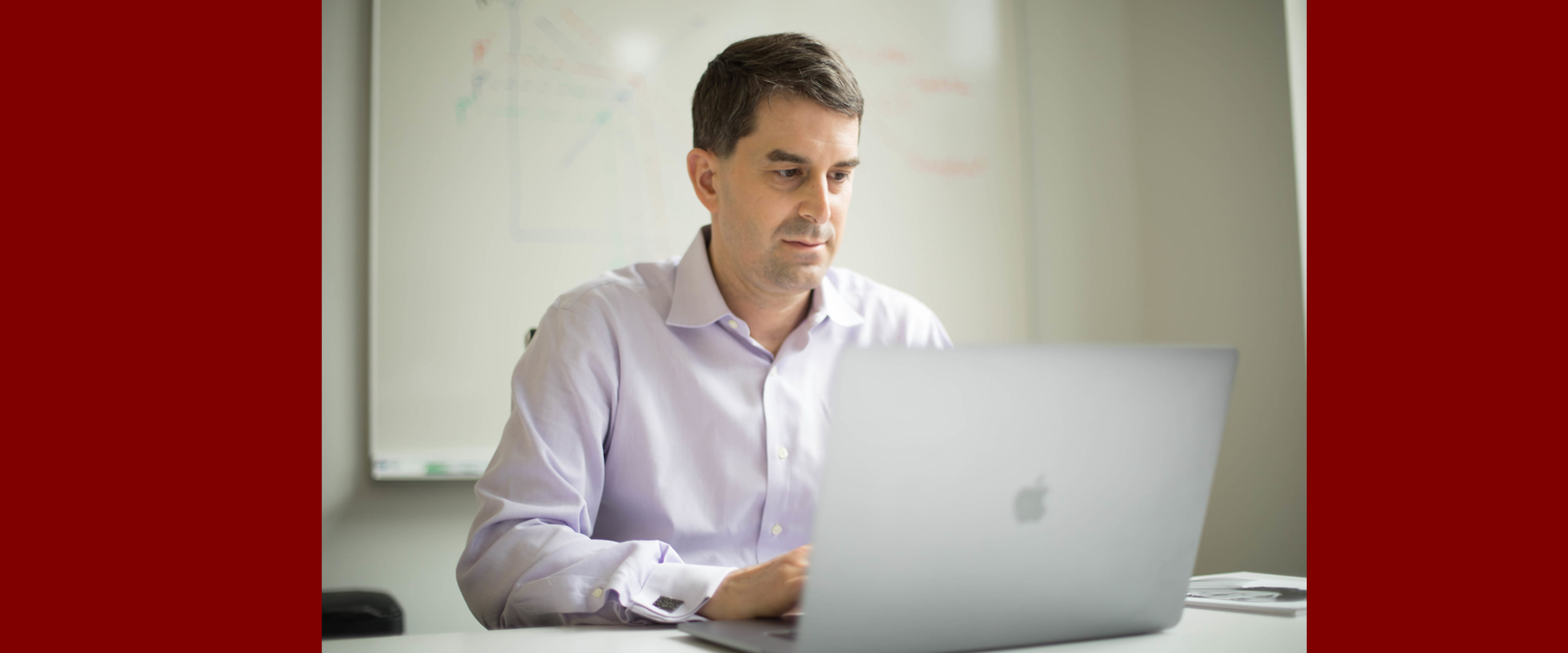 A male Booth Part-Time student sitting at a computer