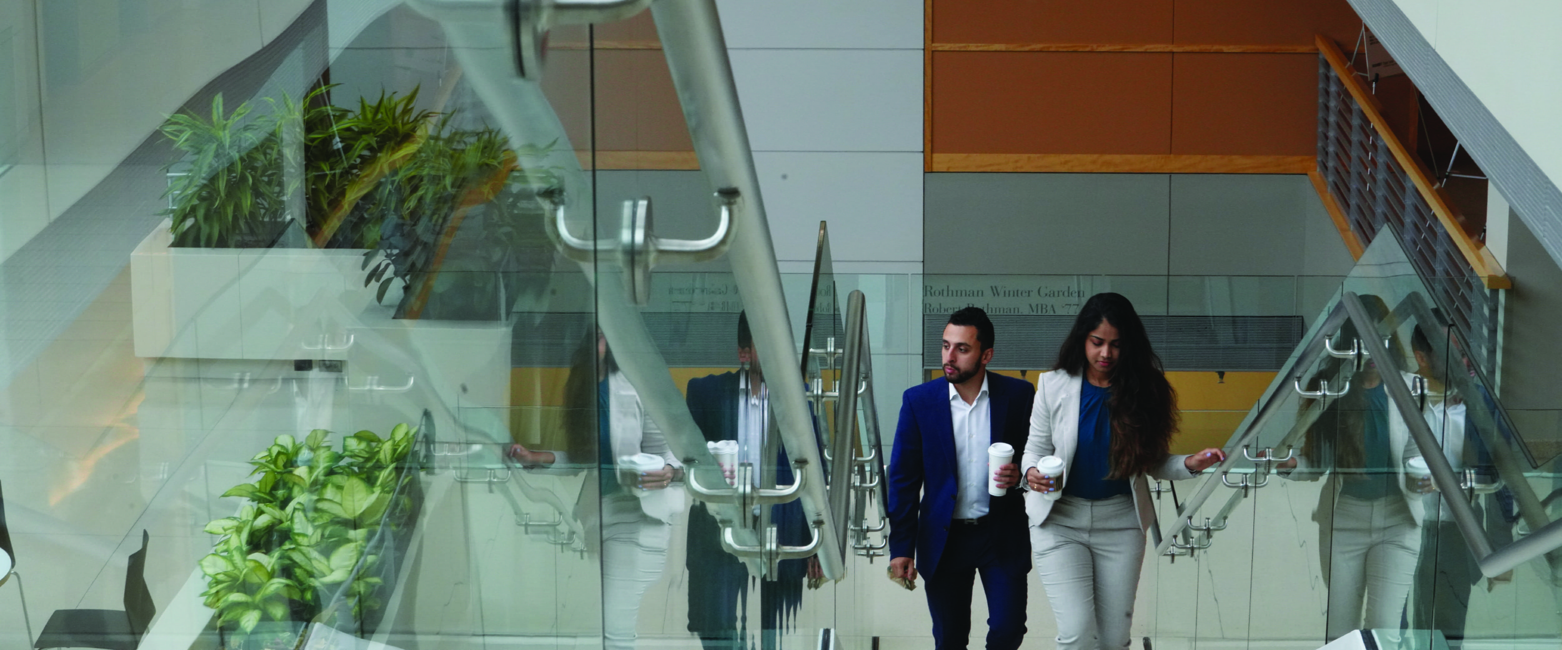 Two booth students walk up the staircase in the Harper Center