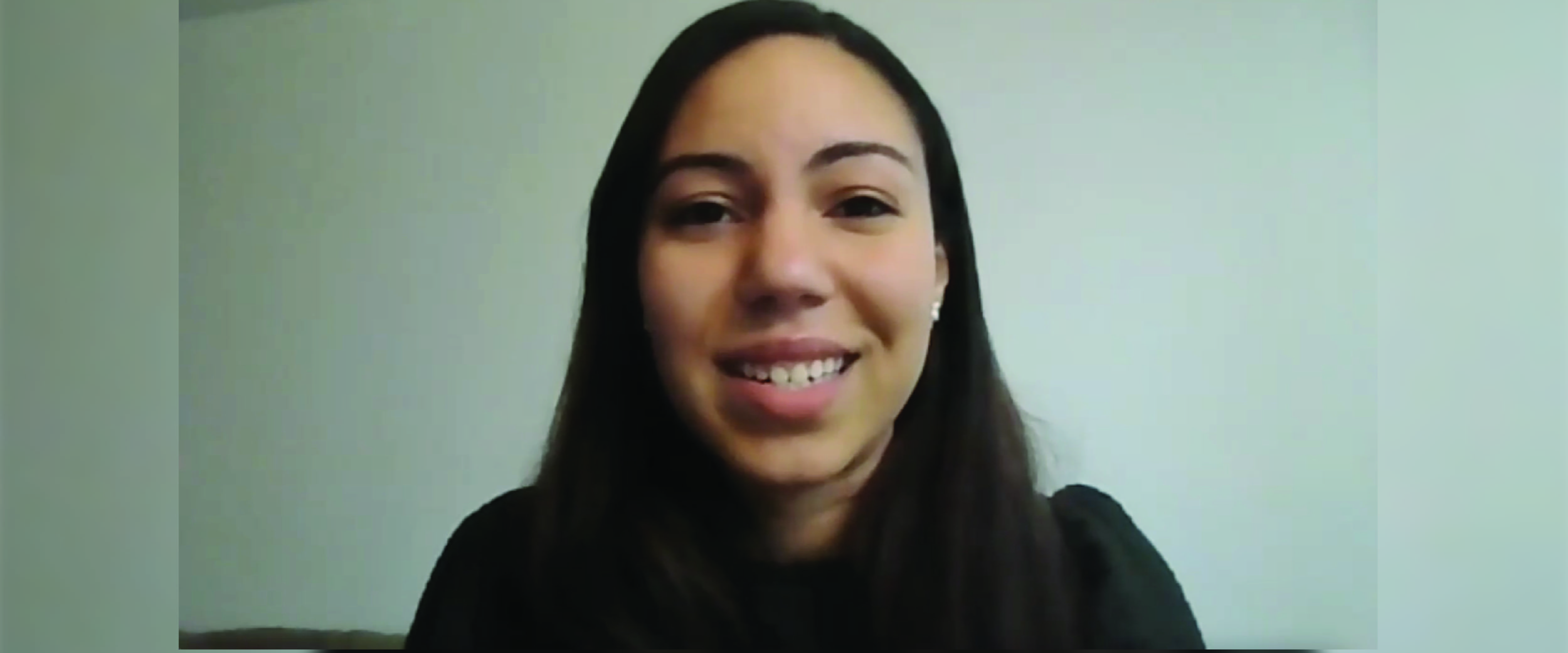 A smiling Booth student looks into the camera during a zoom interview. 