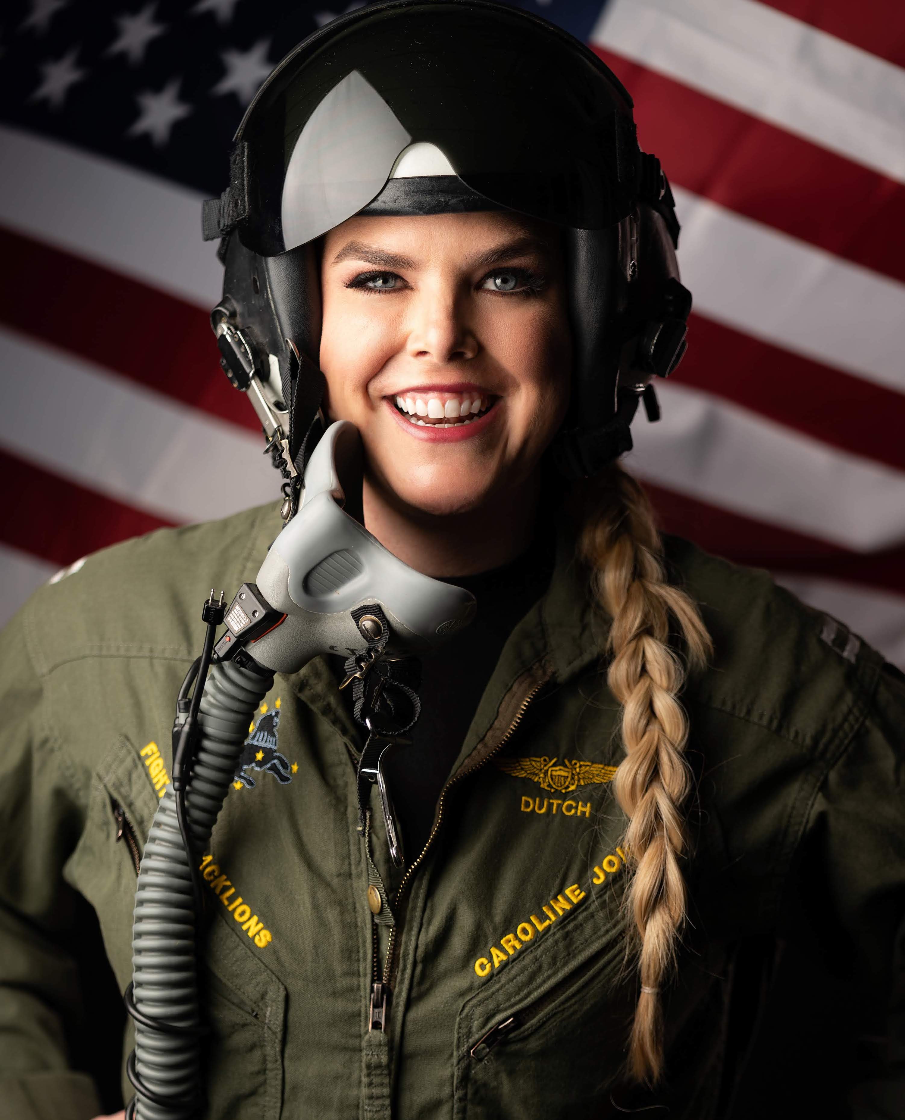 EMBA student Caroline Johnson in military gear standing in front of American flag