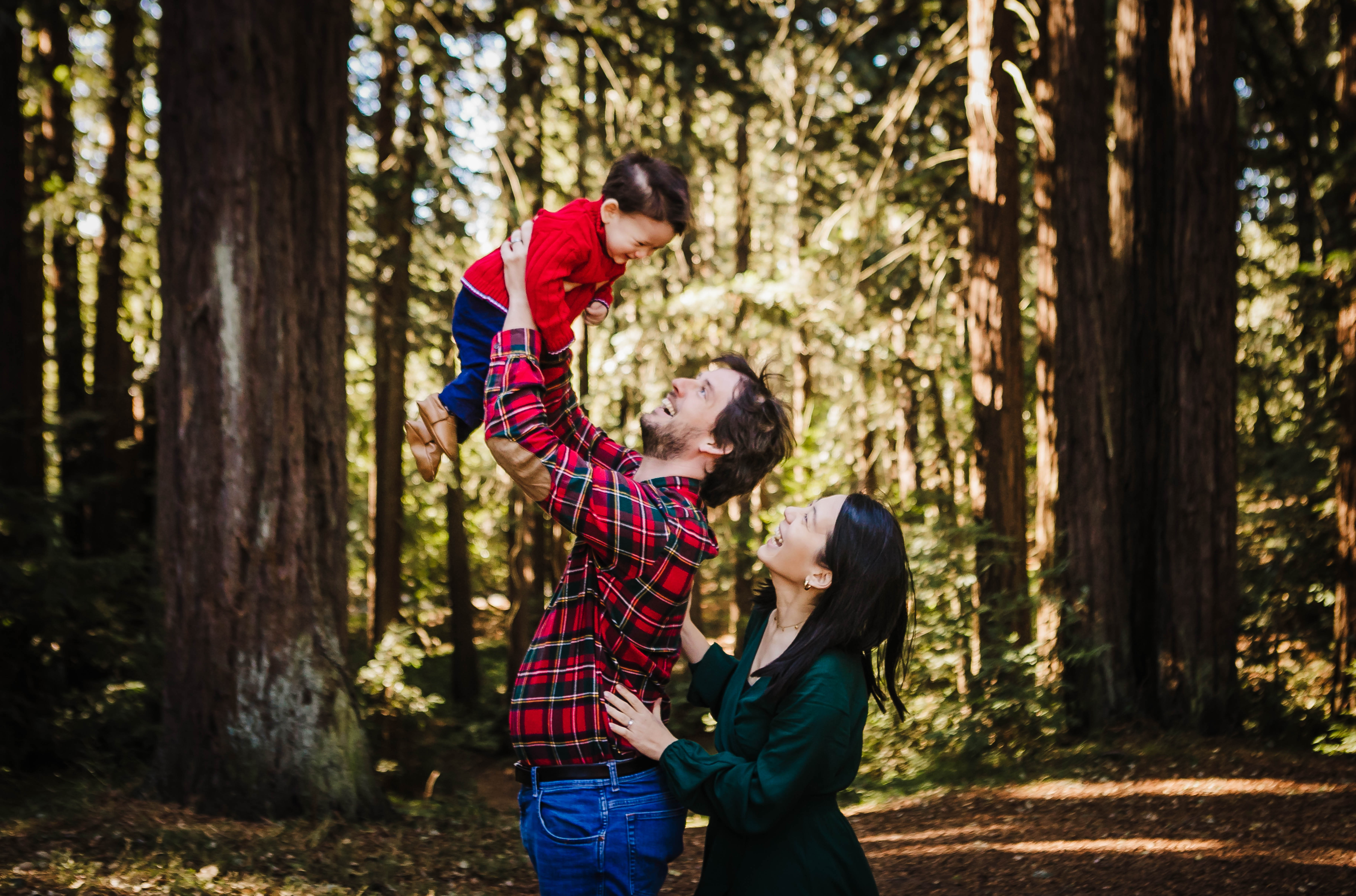 Stephanie Hwu and family lifting her child in the forest