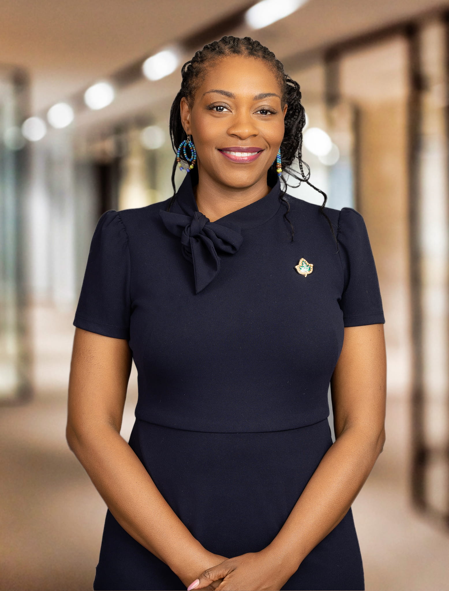 A woman stands and smiles at the camera