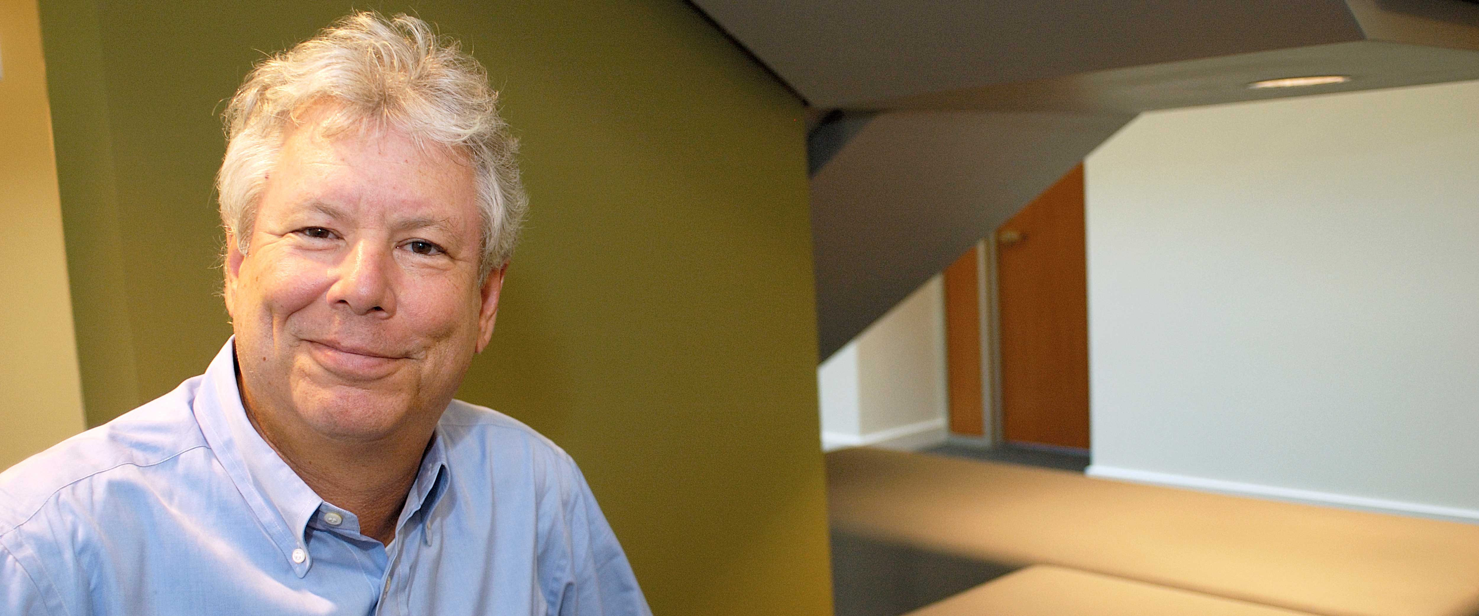 Richard Thaler sitting by the stairs