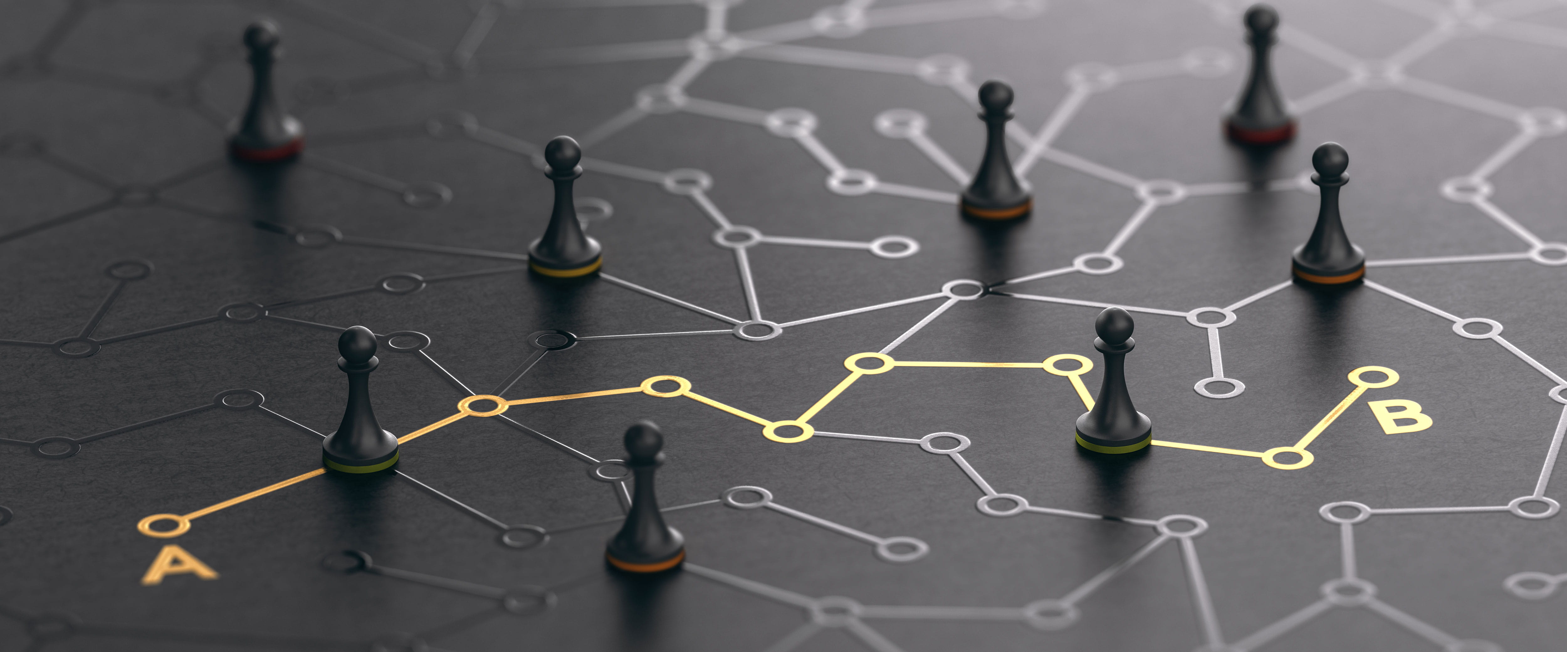 Several chess pieces on a black circuit board with a single gold circuit pointing from point A to point B