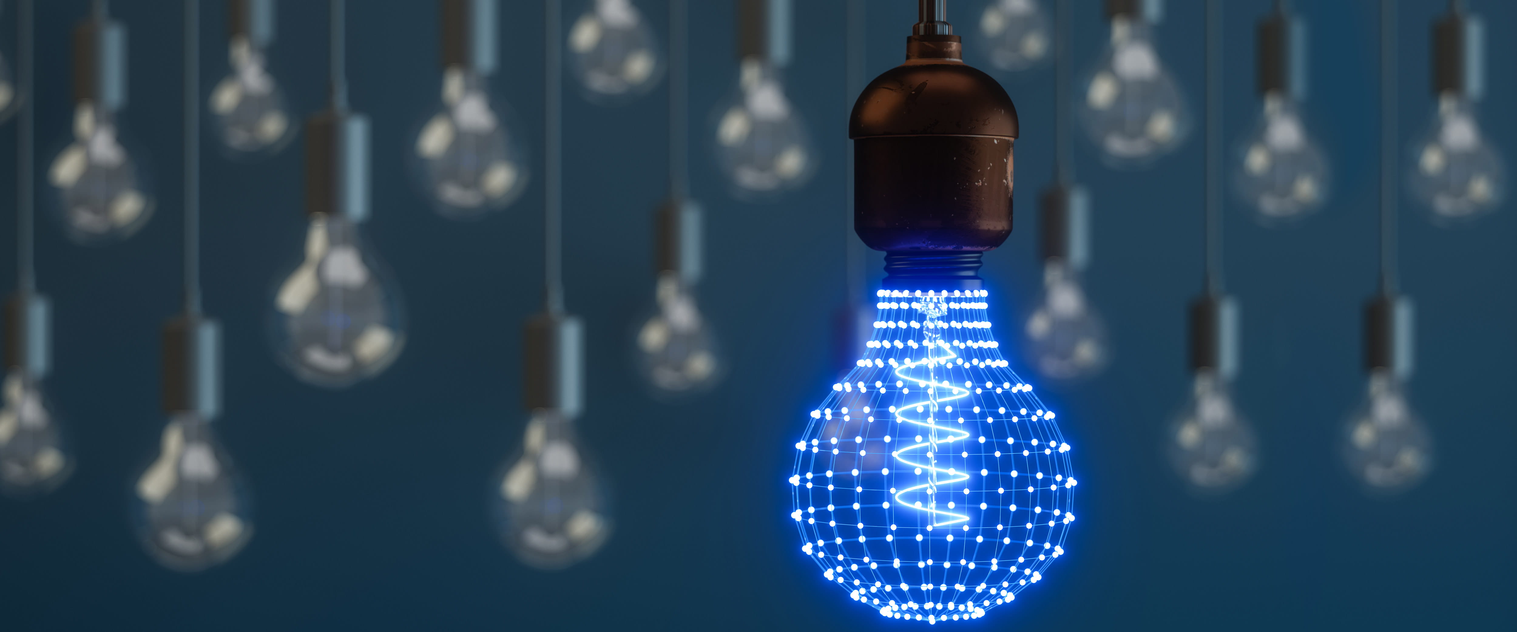 A blue lighbulb made of points of light hangs down in front of several regular lightbulbs