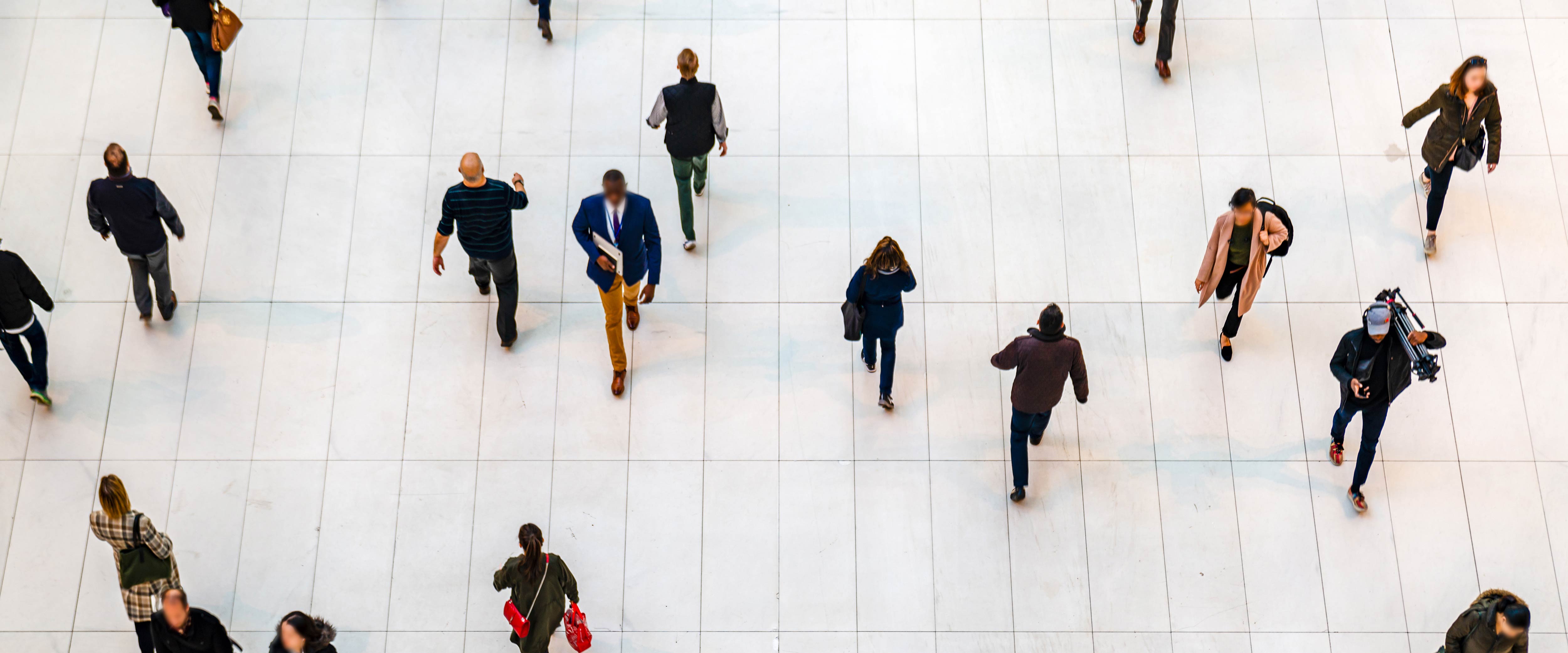 High angle shot of many people walking on a while floor
