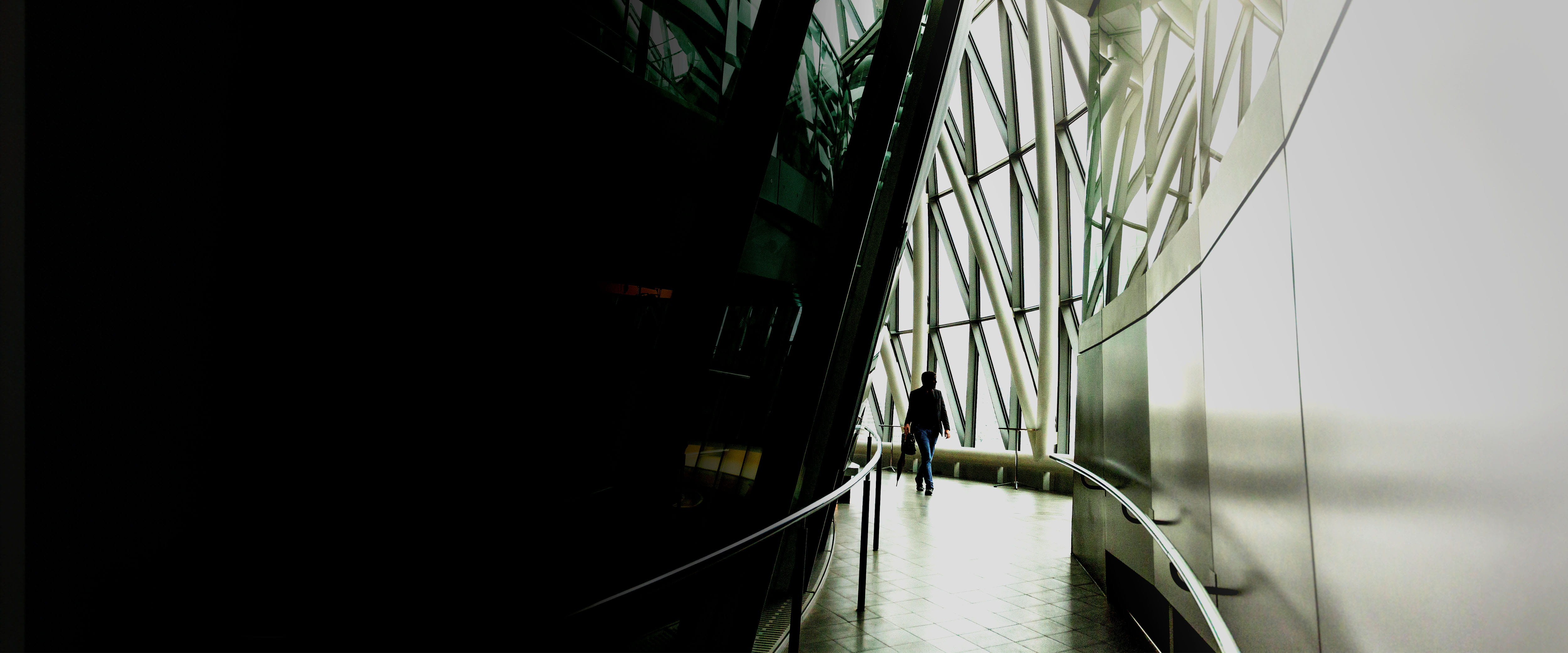 Soming walking down a windowed hallway