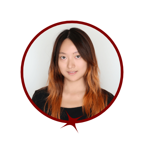 Picture of multi-colored hair woman wearing a black shirt and standing in front of a grey background. 
