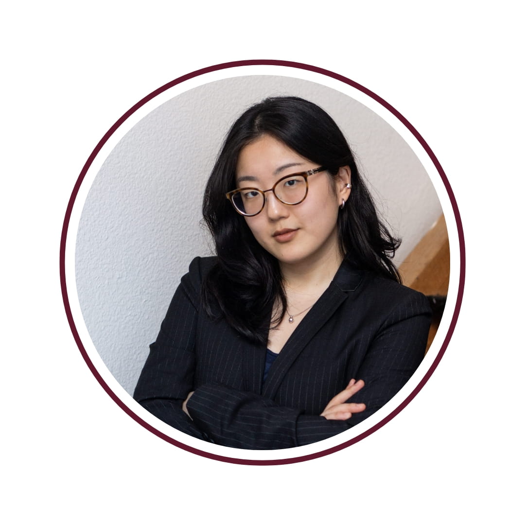 dark haired woman with glasses in blazer
