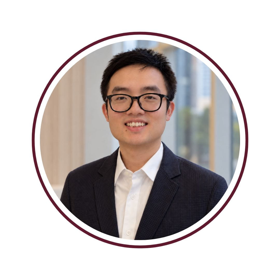 Smiling black-haired man wearing a blue blazer and a white shirt.