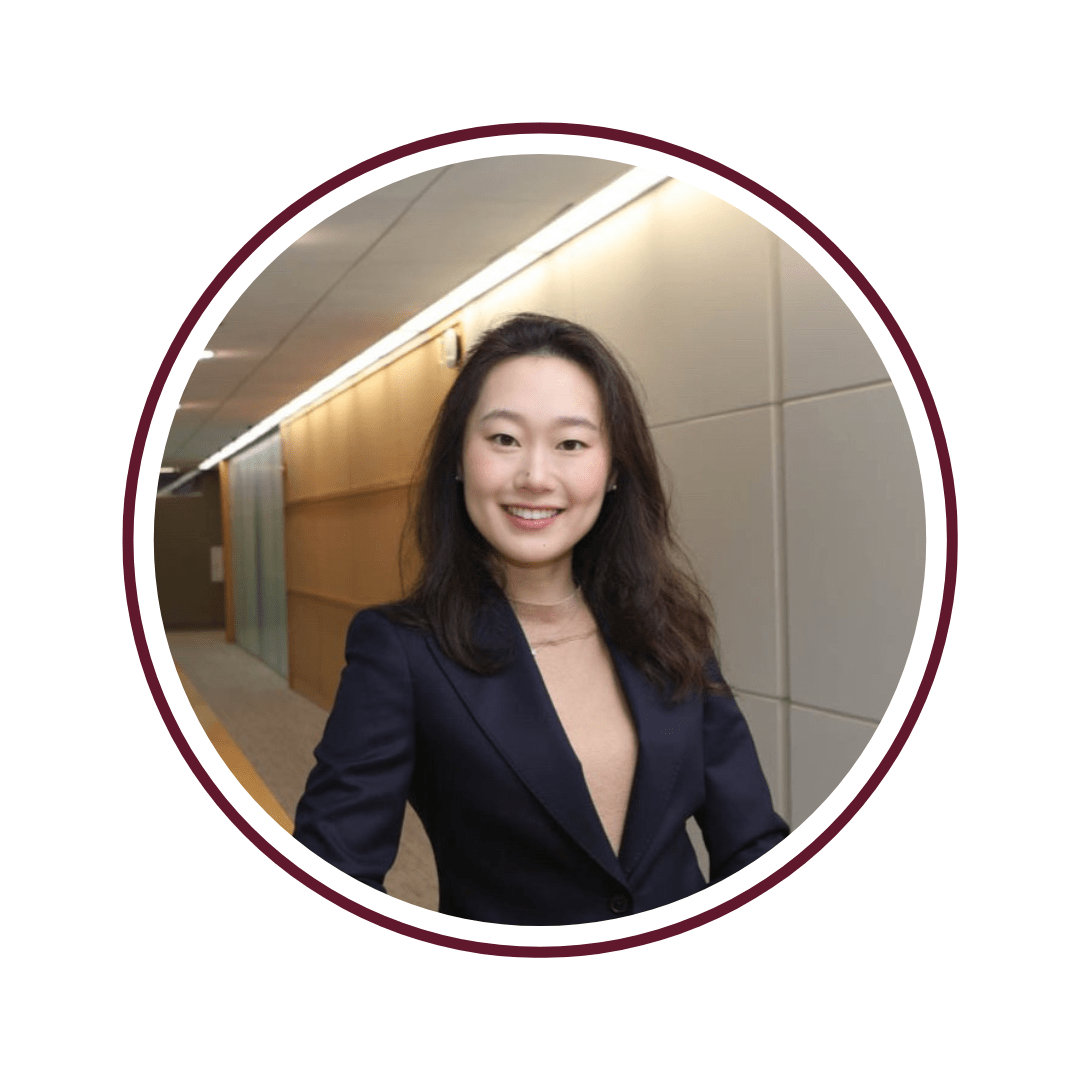 Picture of smiling, dark-haired young woman wearing a black professional shirt and pearl earrings. 
