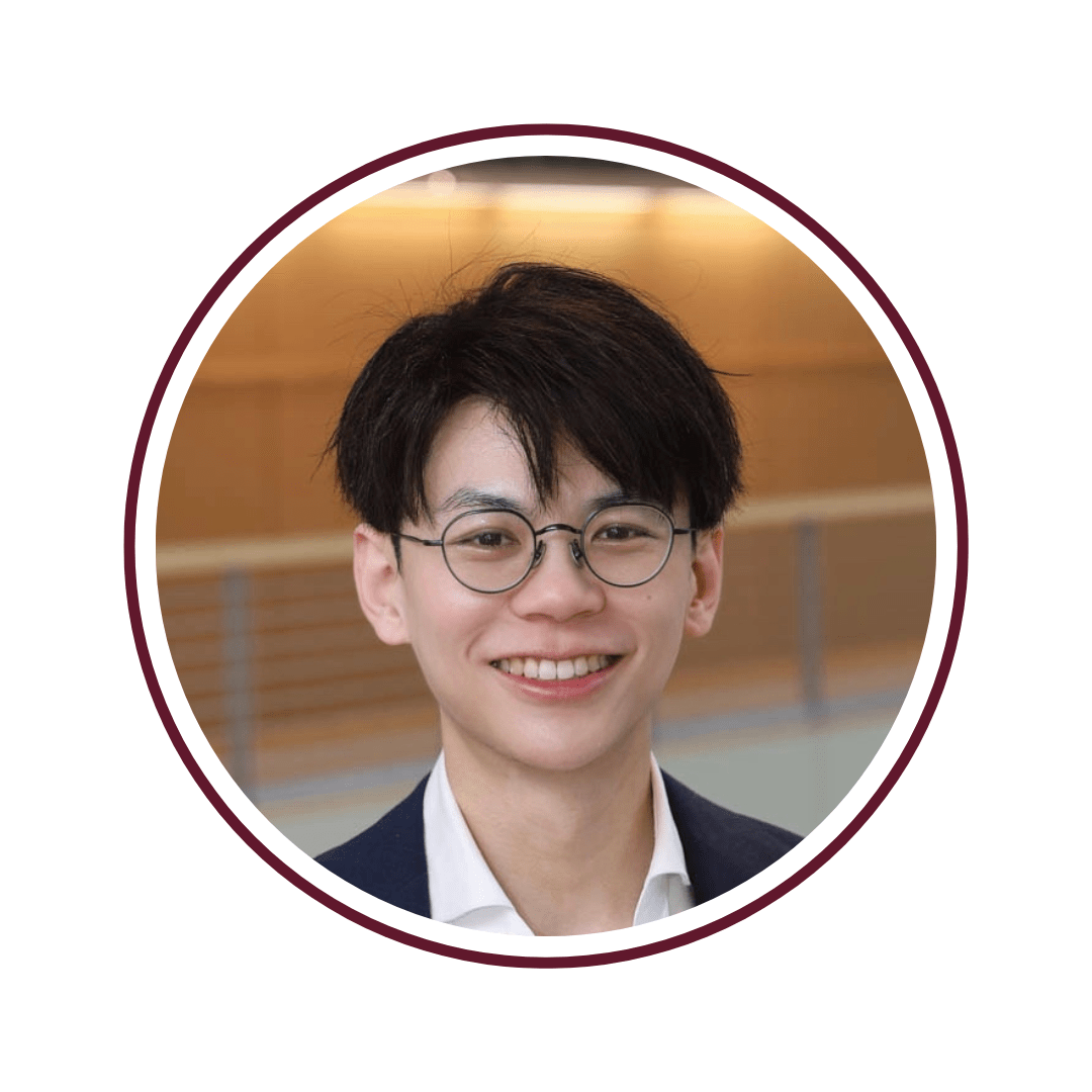 Picture of smiling, dark-haired man wearing glasses and a blazer. 